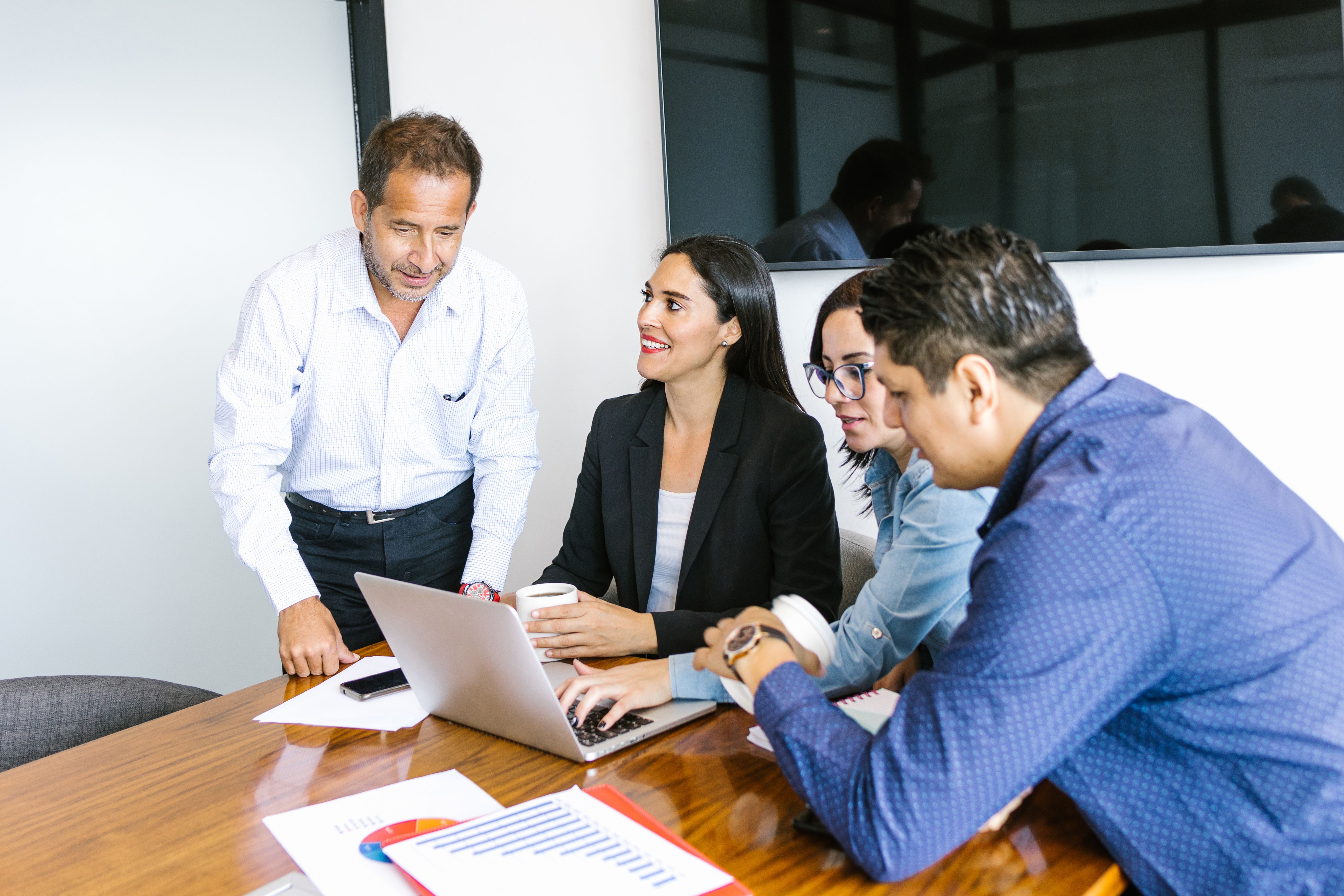 Latin business people with computer collaborating on project in the office in Latin America Latin business people with computer collaborating on project in the office in Latin America