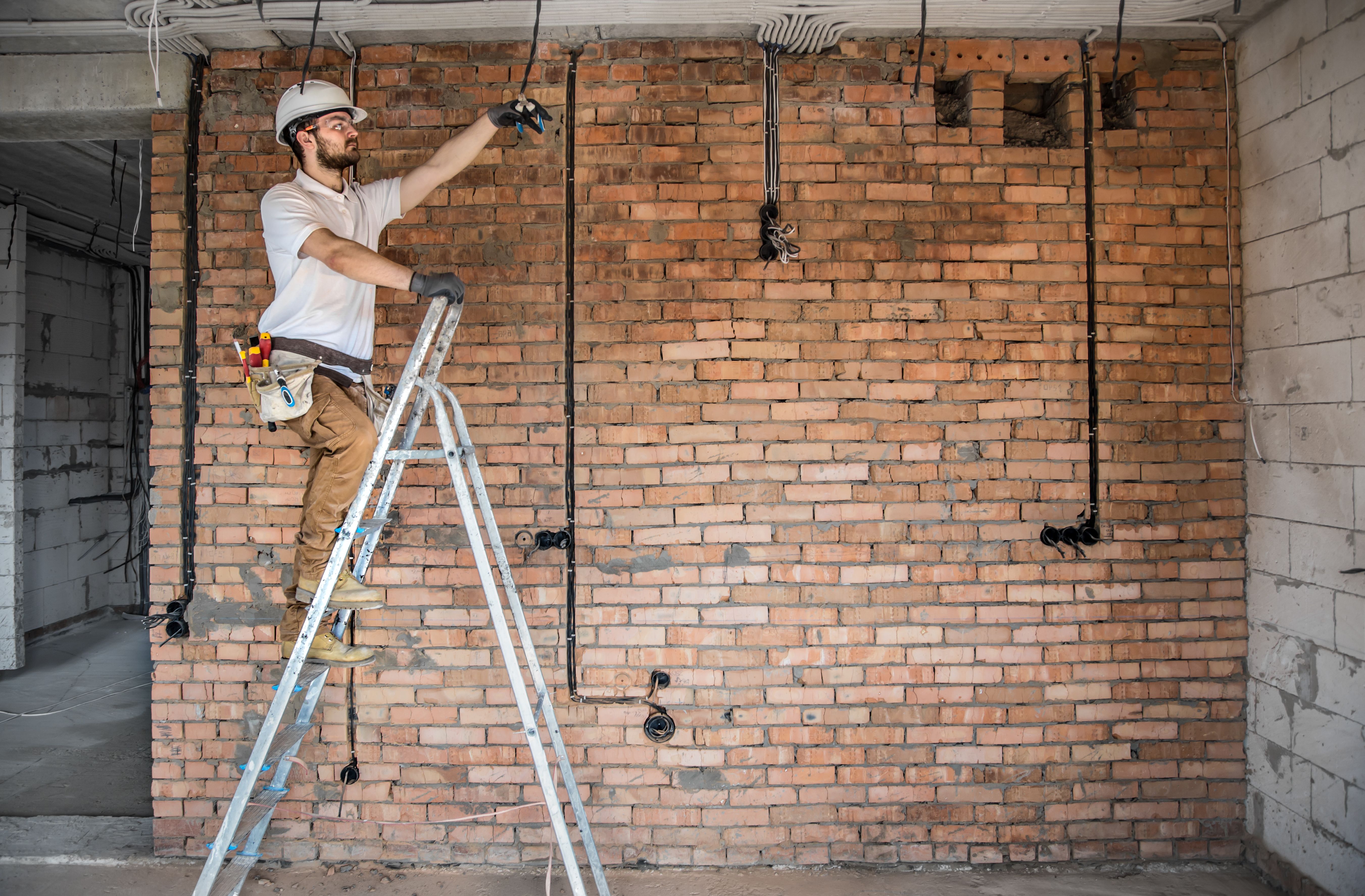 Electrician with tools, working on a construction site. Repair and handyman concept. Electrician with tools, working on a construction site. Repair and handyman concept.