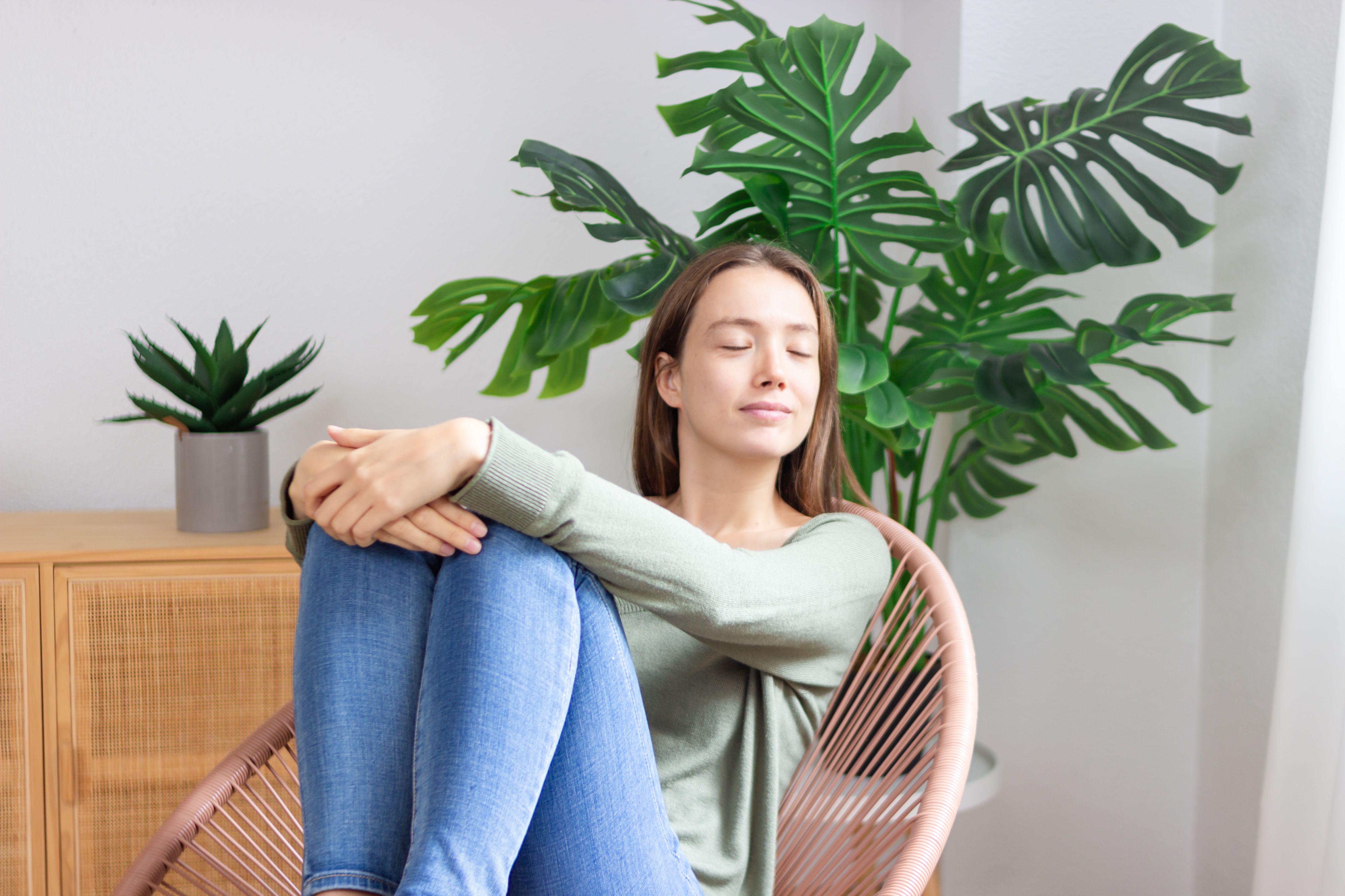 Young woman relaxing at home with houseplants enjoying peaceful atmosphere Young woman relaxing at home with houseplants enjoying peaceful atmosphere