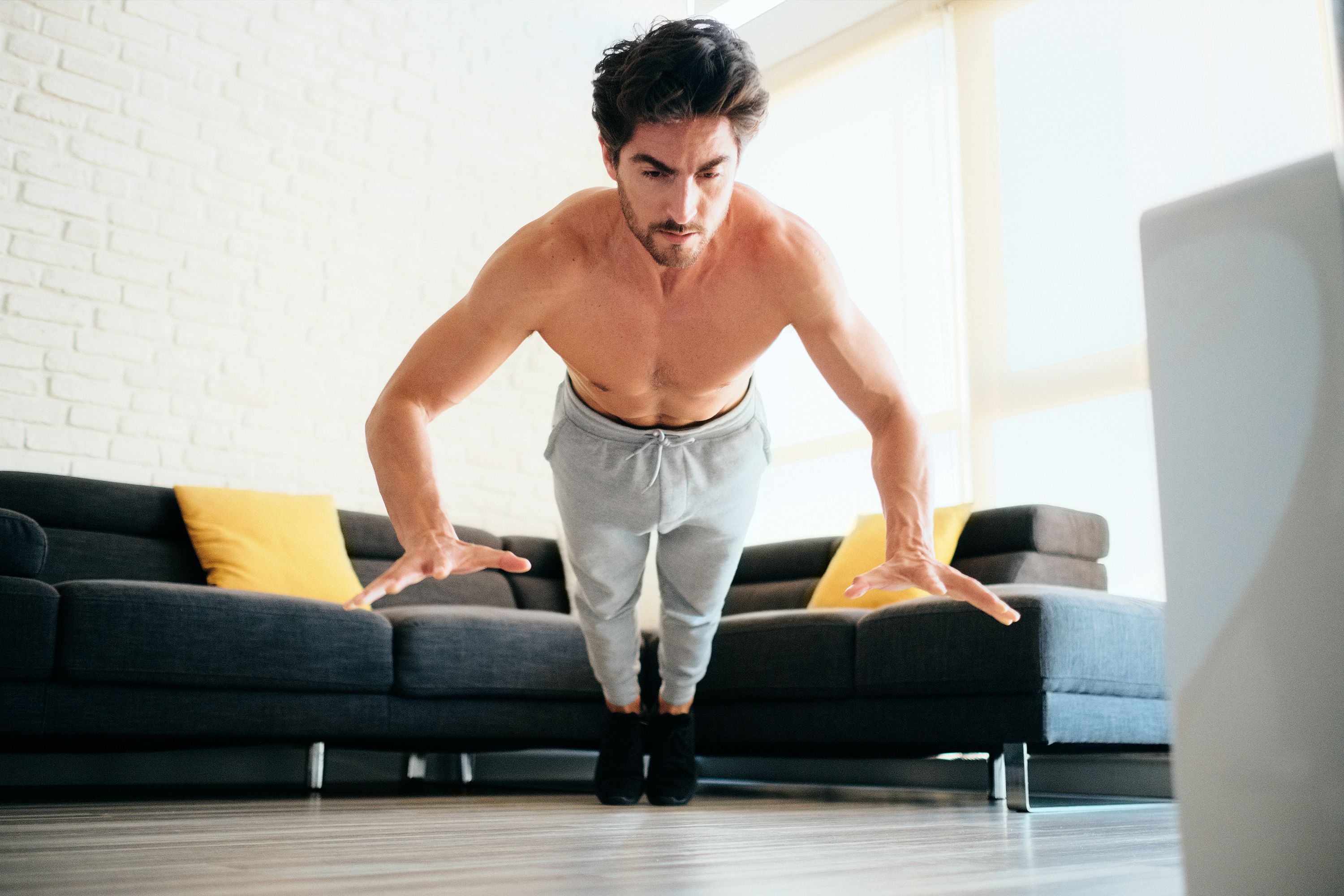 Adult Man Training Chest Muscles At Home Doing Explosive Push-Ups