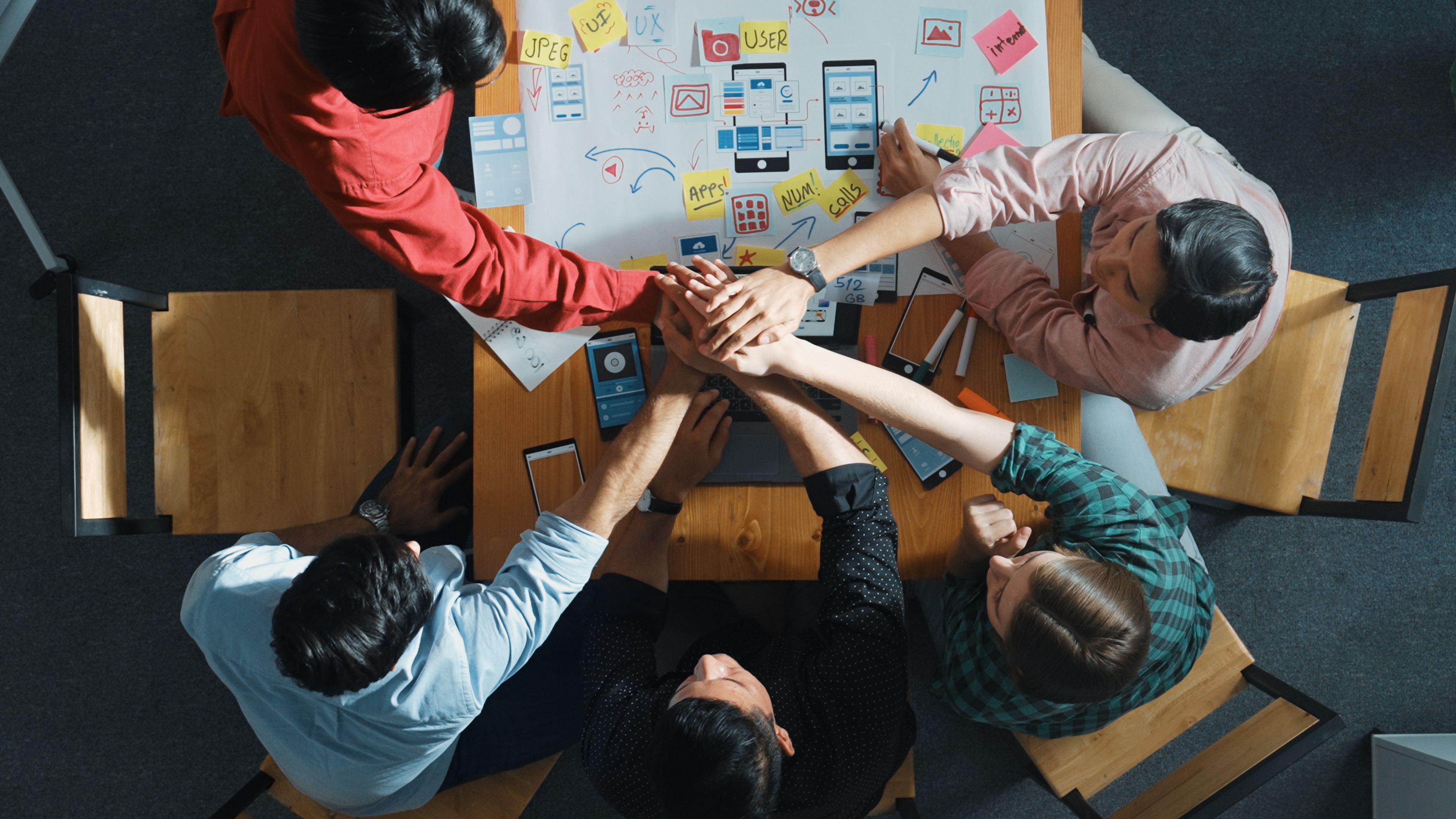 Smart team discuss about Ux Ui design while putting hand together. Convocation.