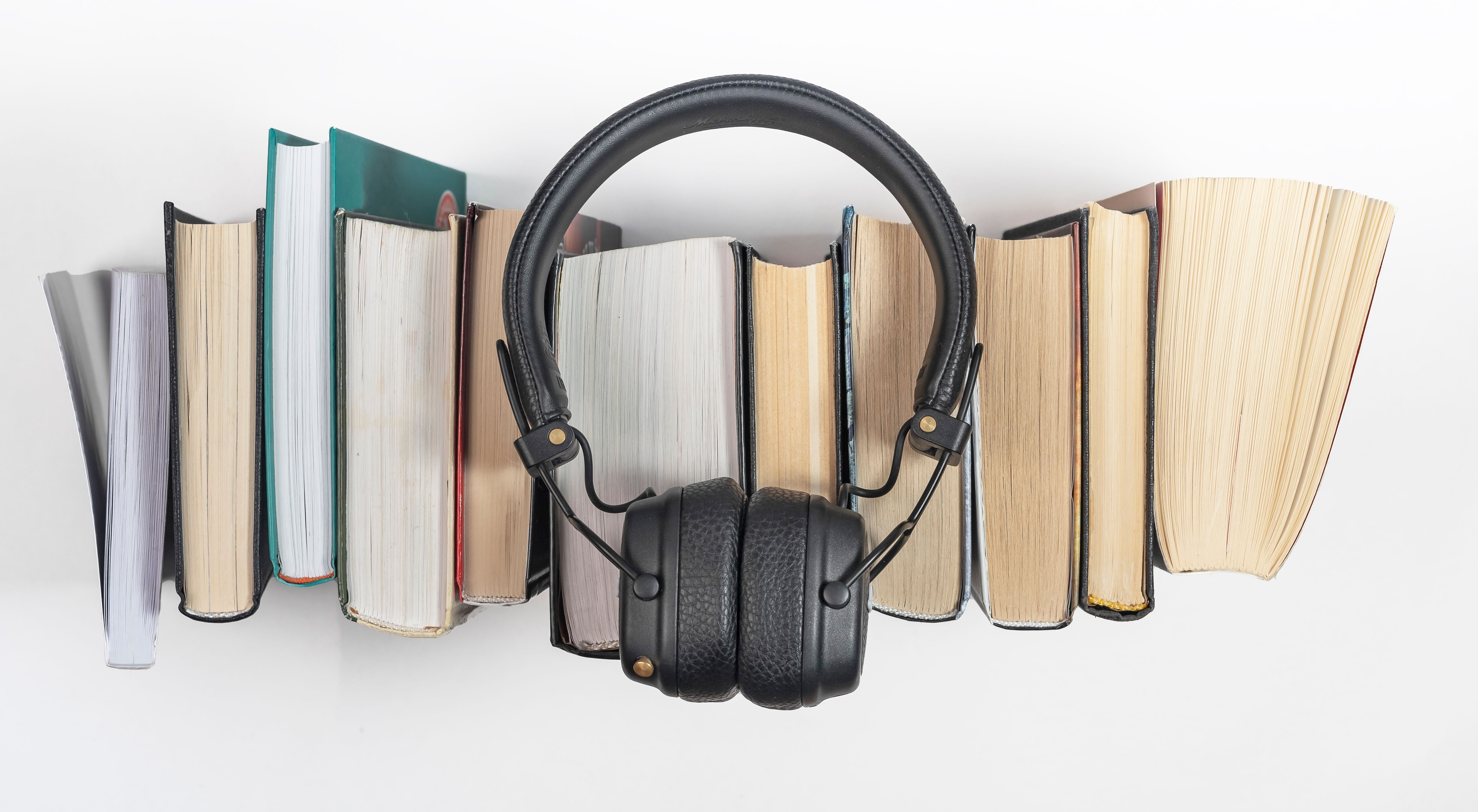 Audio books stack with headphones, top view. Audiobook reading concept