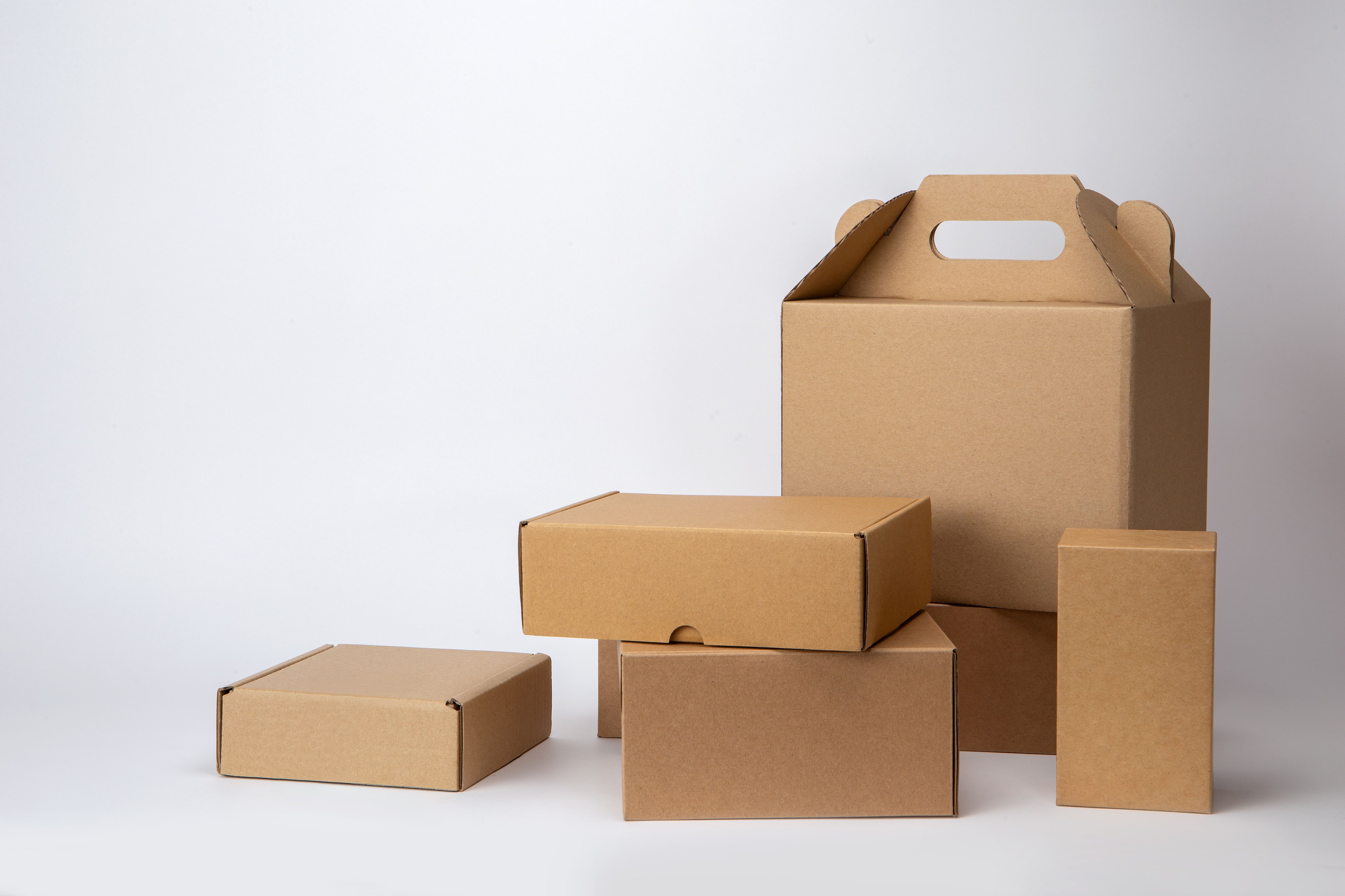 Paper container and brown cardboard boxes in various sizes isolated on white background