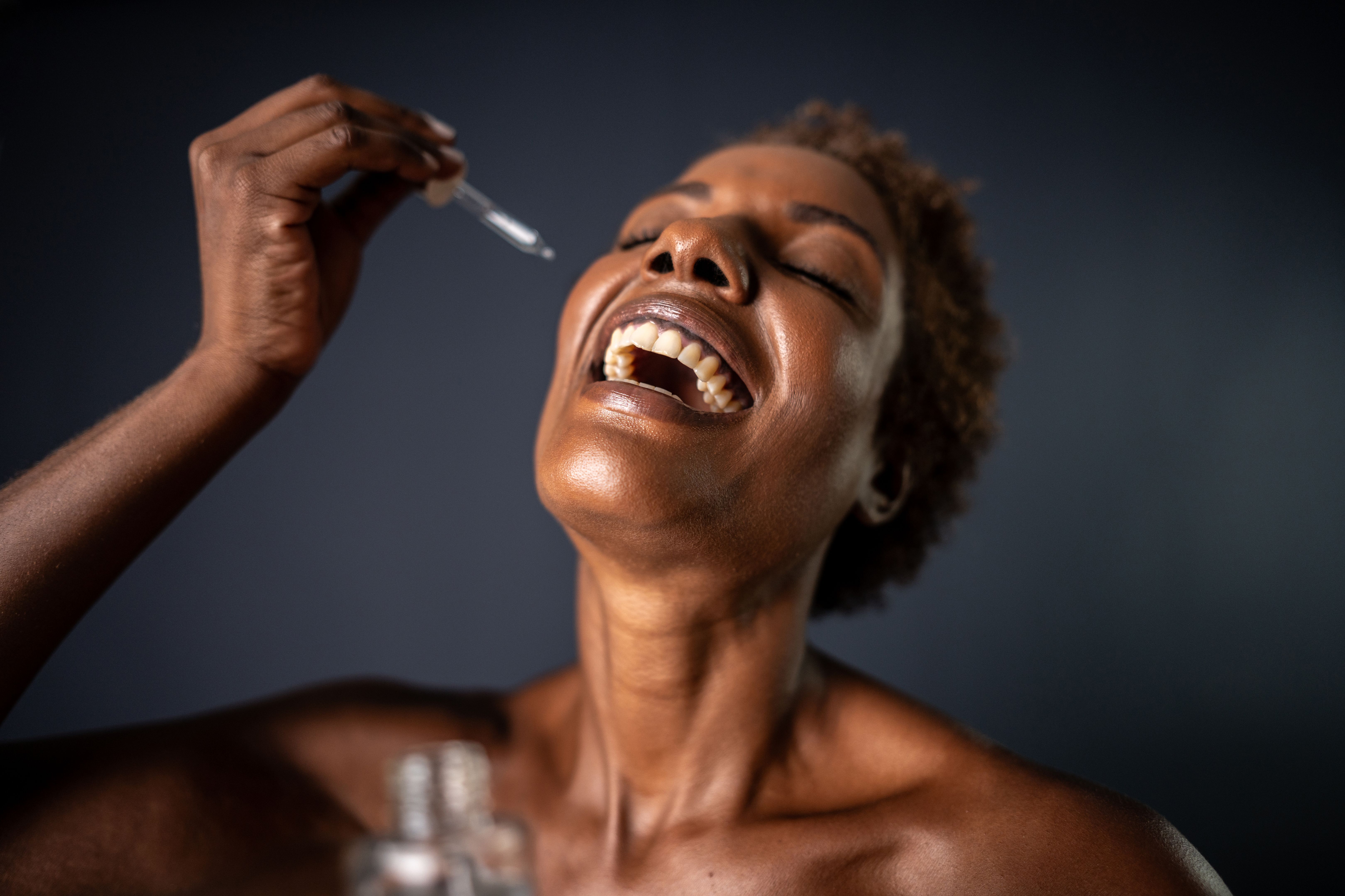 Mature woman holding face serum on a studio shot