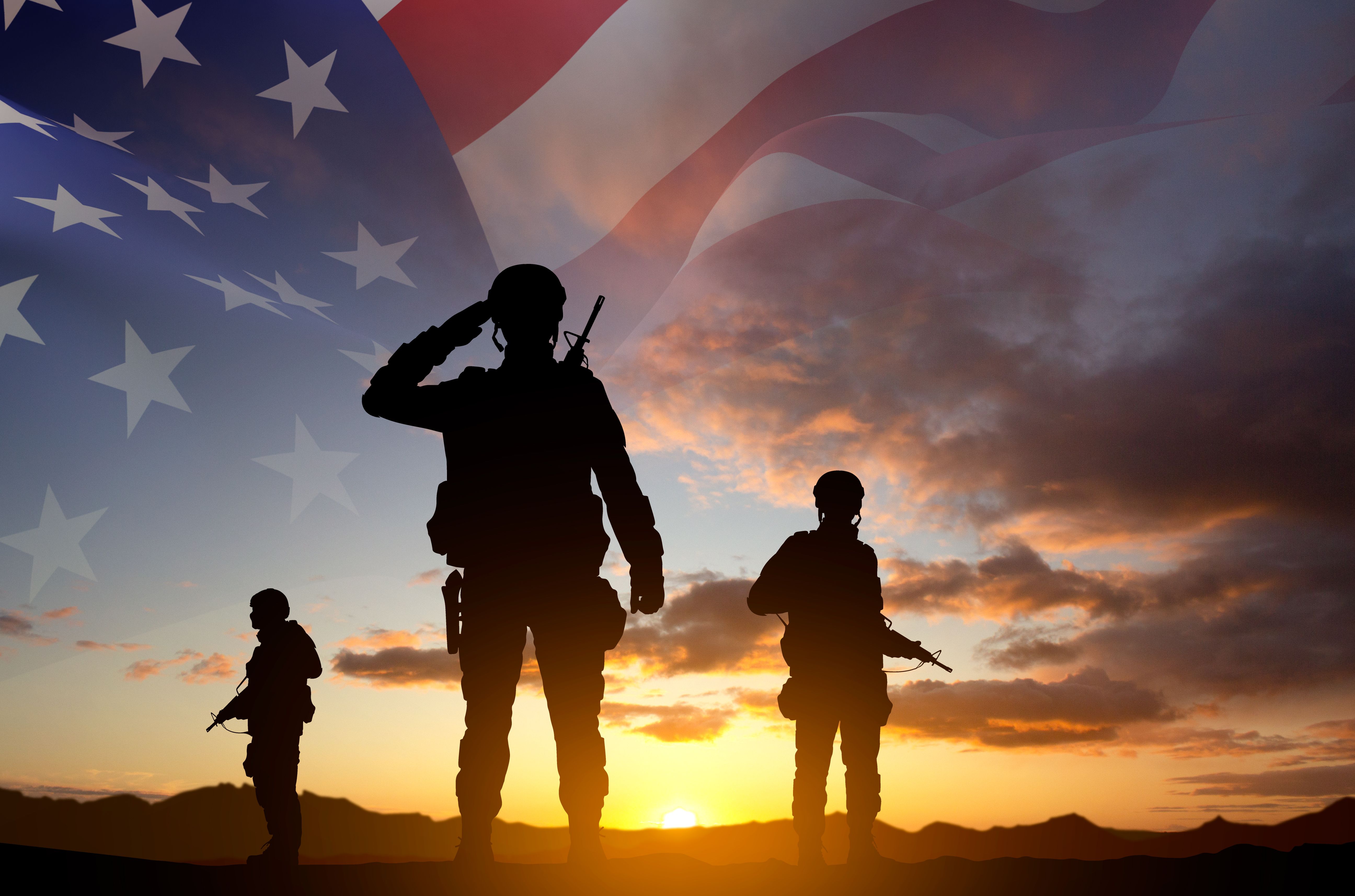 Silhouettes of a soldiers with USA flag