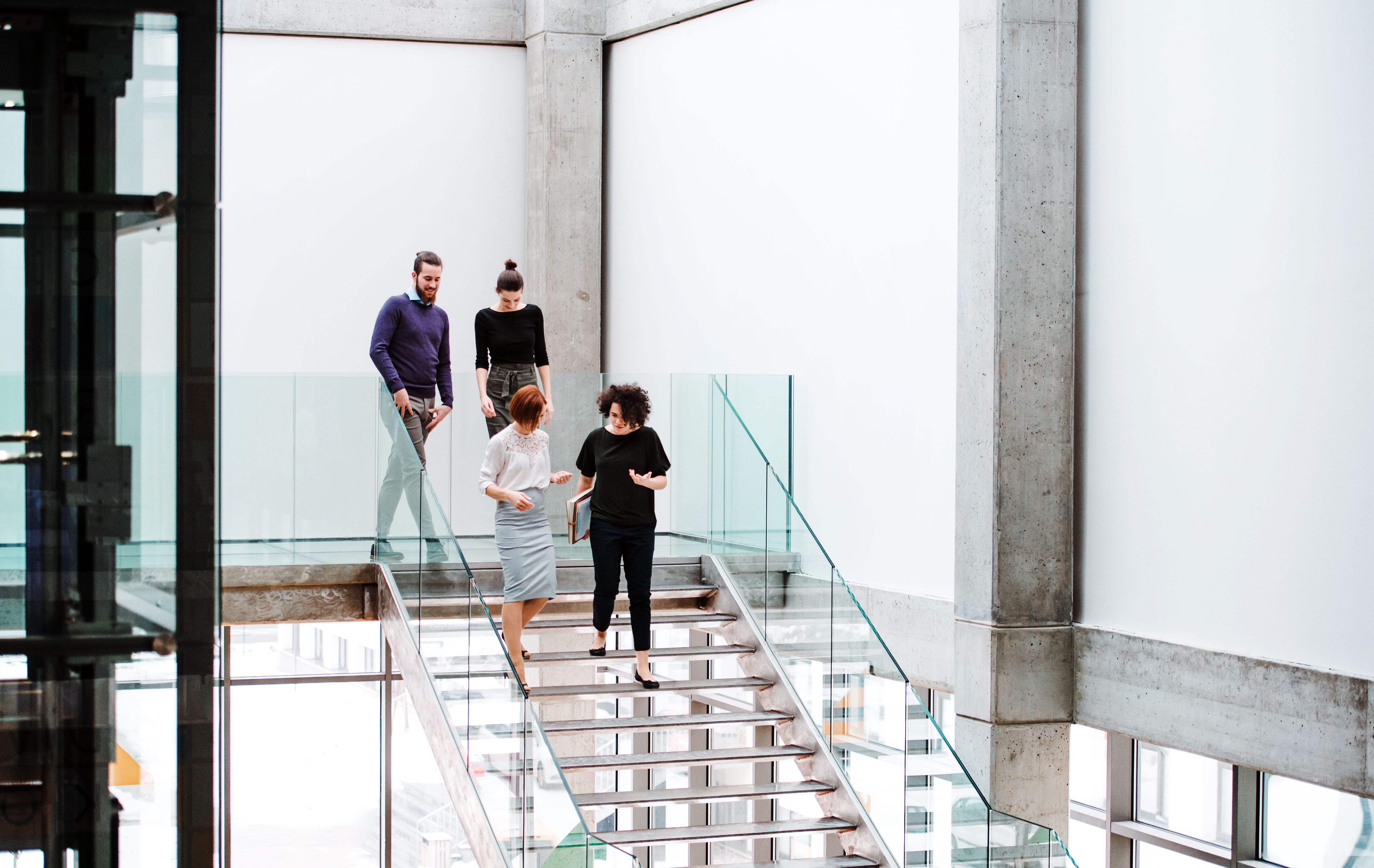 Group of young businesspeople walking down the stairs, talking. Group of young businesspeople walking down the stairs, talking.