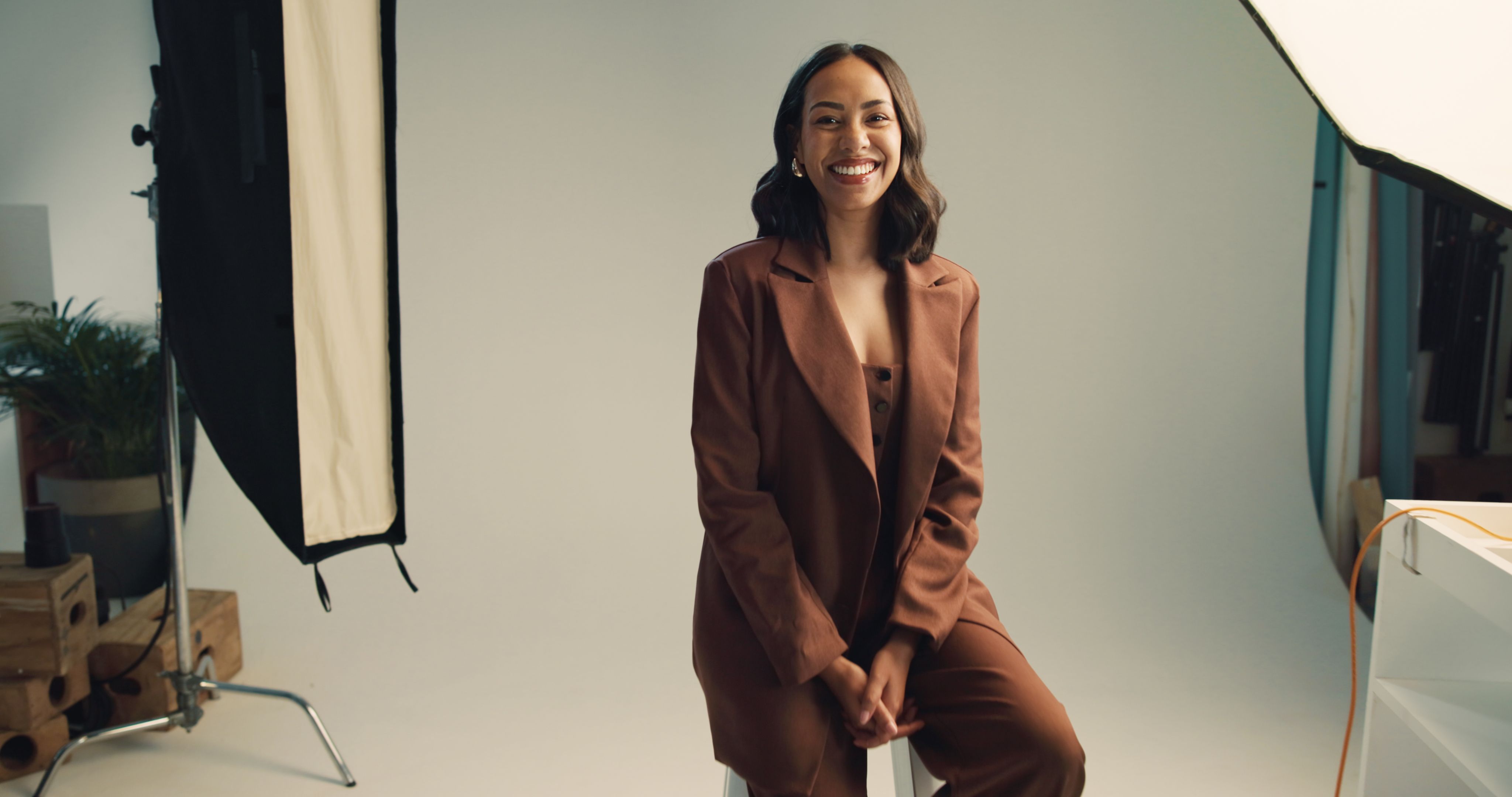 Photography, studio and model with portrait backstage for fashion photoshoot, magazine catalog and creative career. Behind the scenes, woman and happy on set for campaign project and article cover