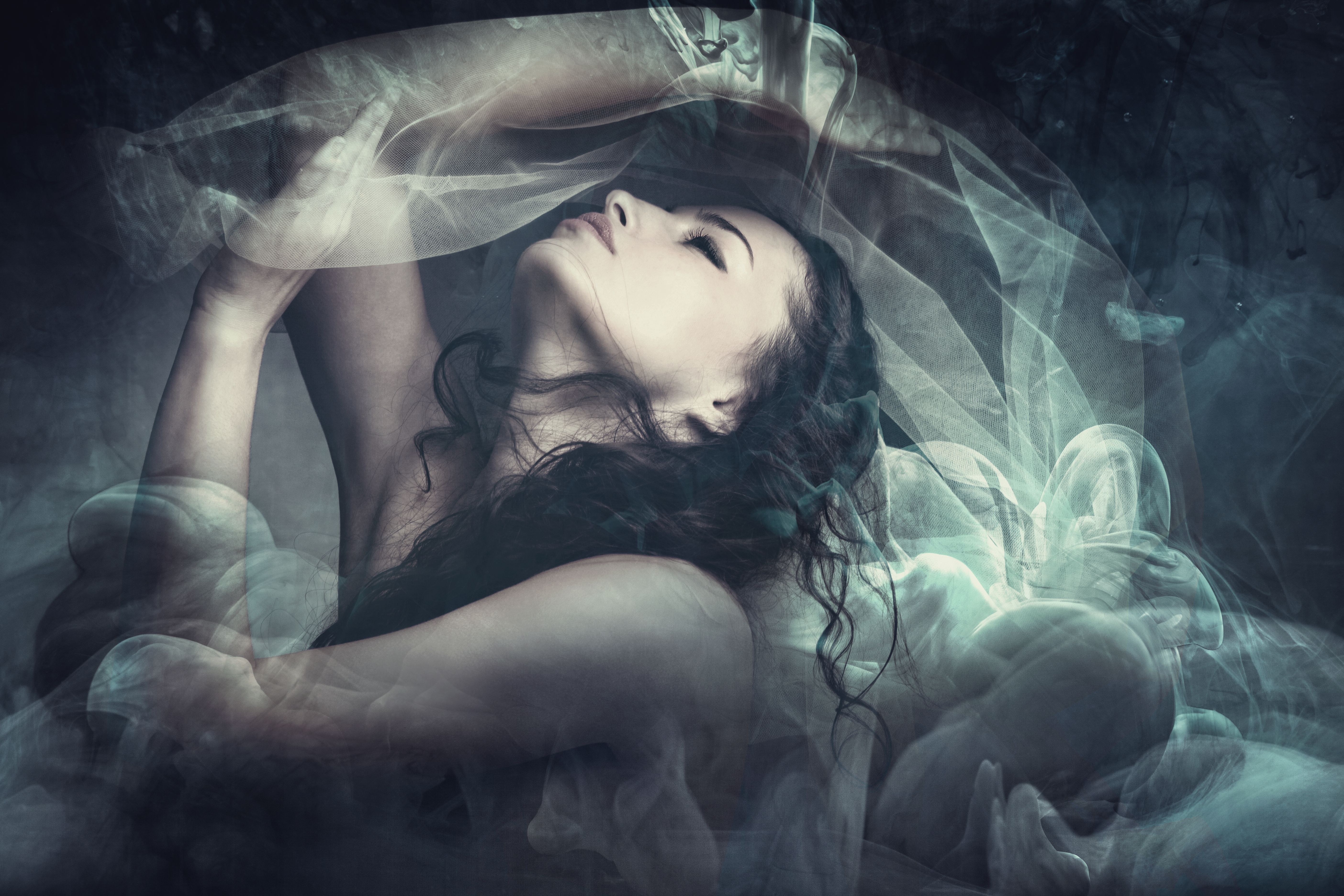 Woman in dancing motion under the black veil in a fairy-like fantasy Woman in dancing motion under the black veil in a fairy-like fantasy