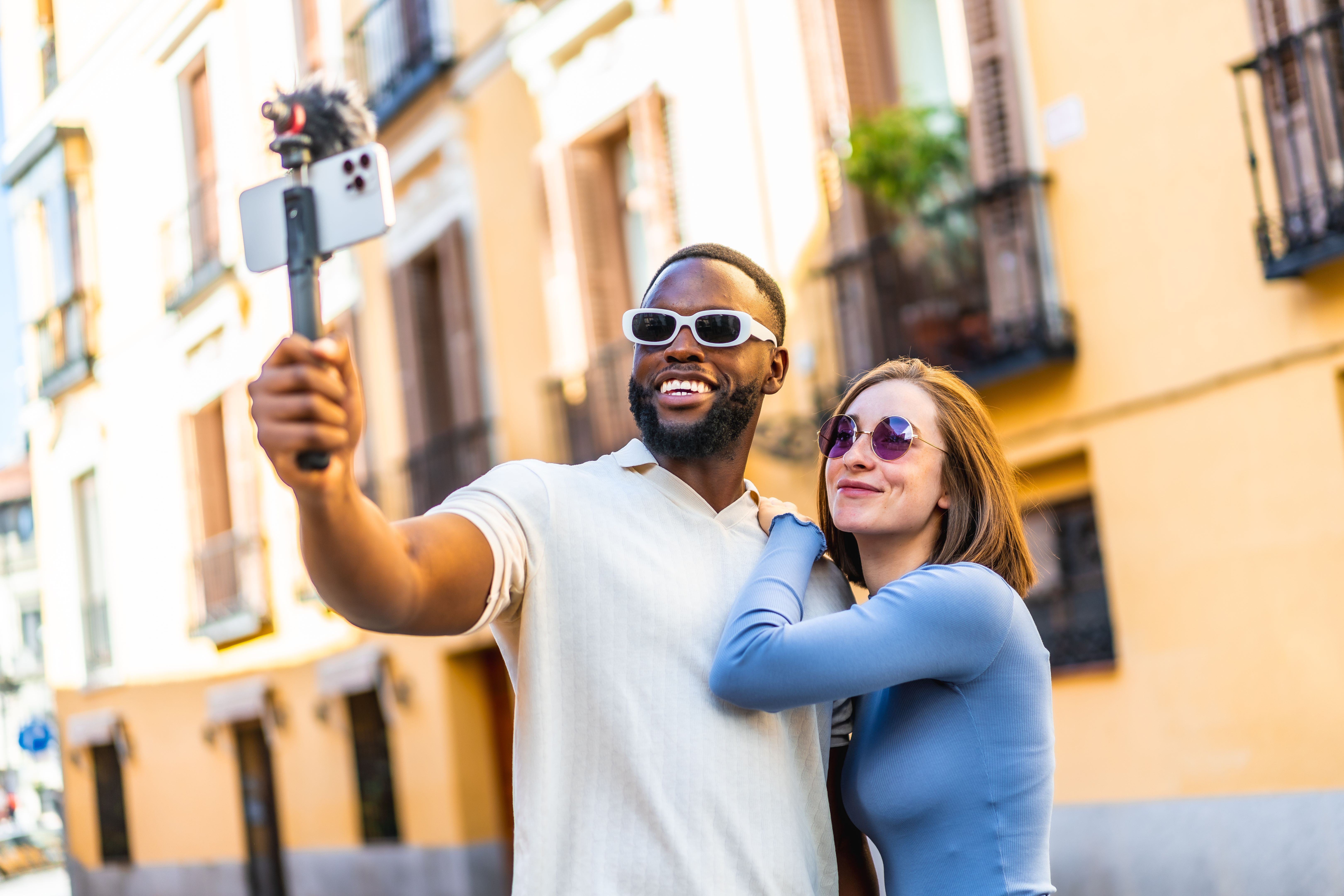Multi-ethnic couple recording video vlog with smartphone in the city