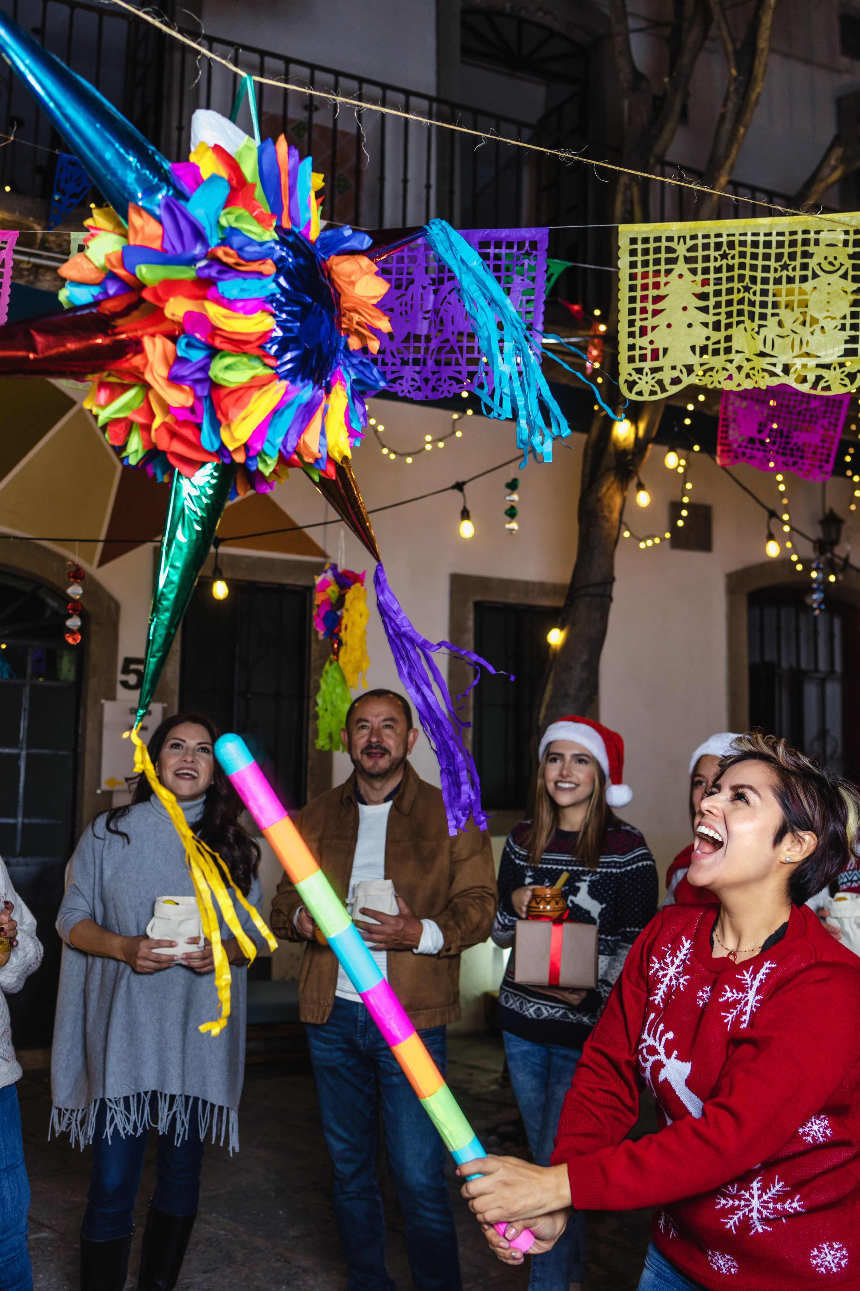 Mexican family breaking a piñata at traditional posada party for Christmas in Mexico Latin America, hispanic people