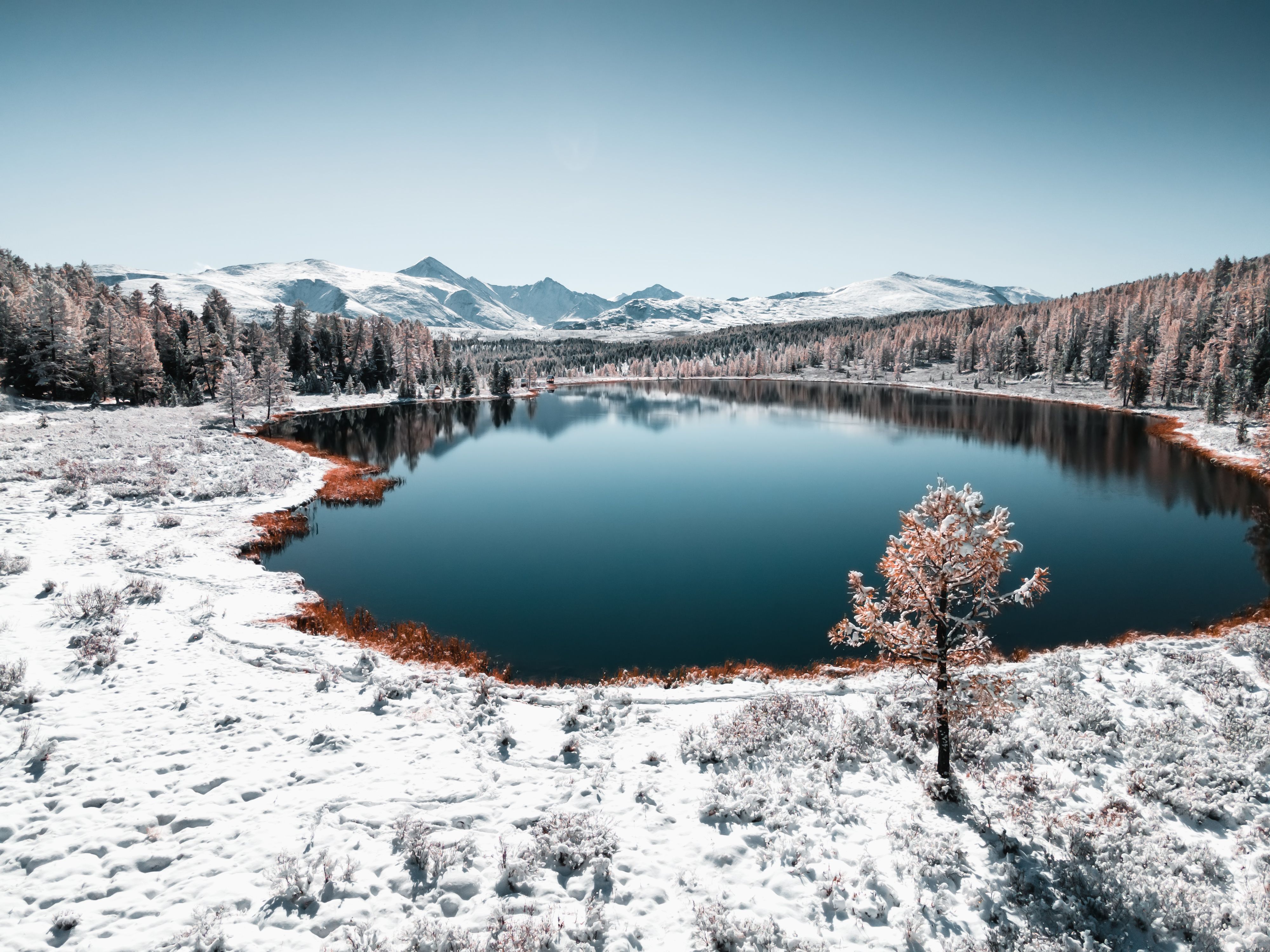 Kidelu lake in Altai mountains, Siberia, Russia. Snow-covered trees and mountains.