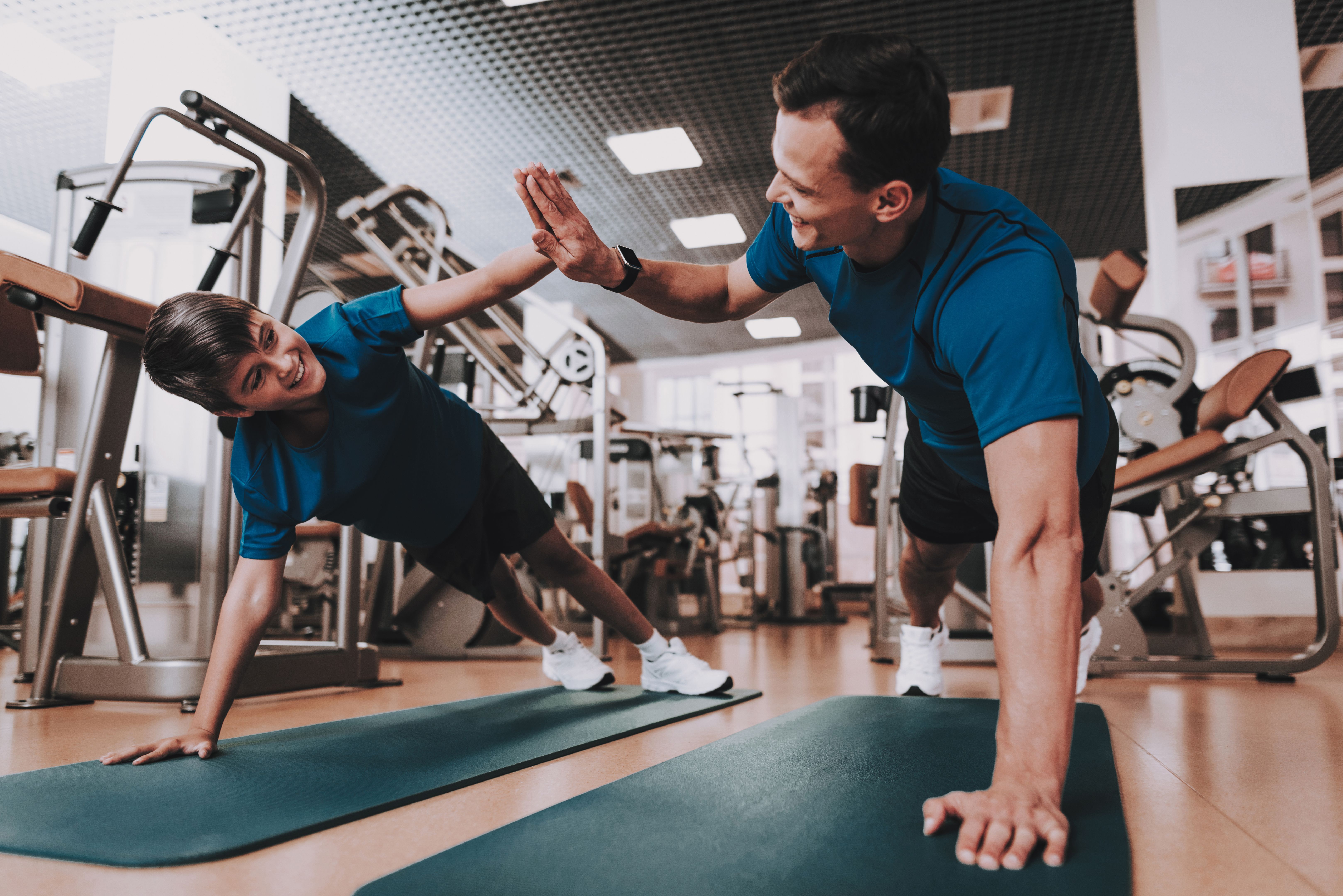 Jovem pai e filho fazendo exercícios no esporte clube