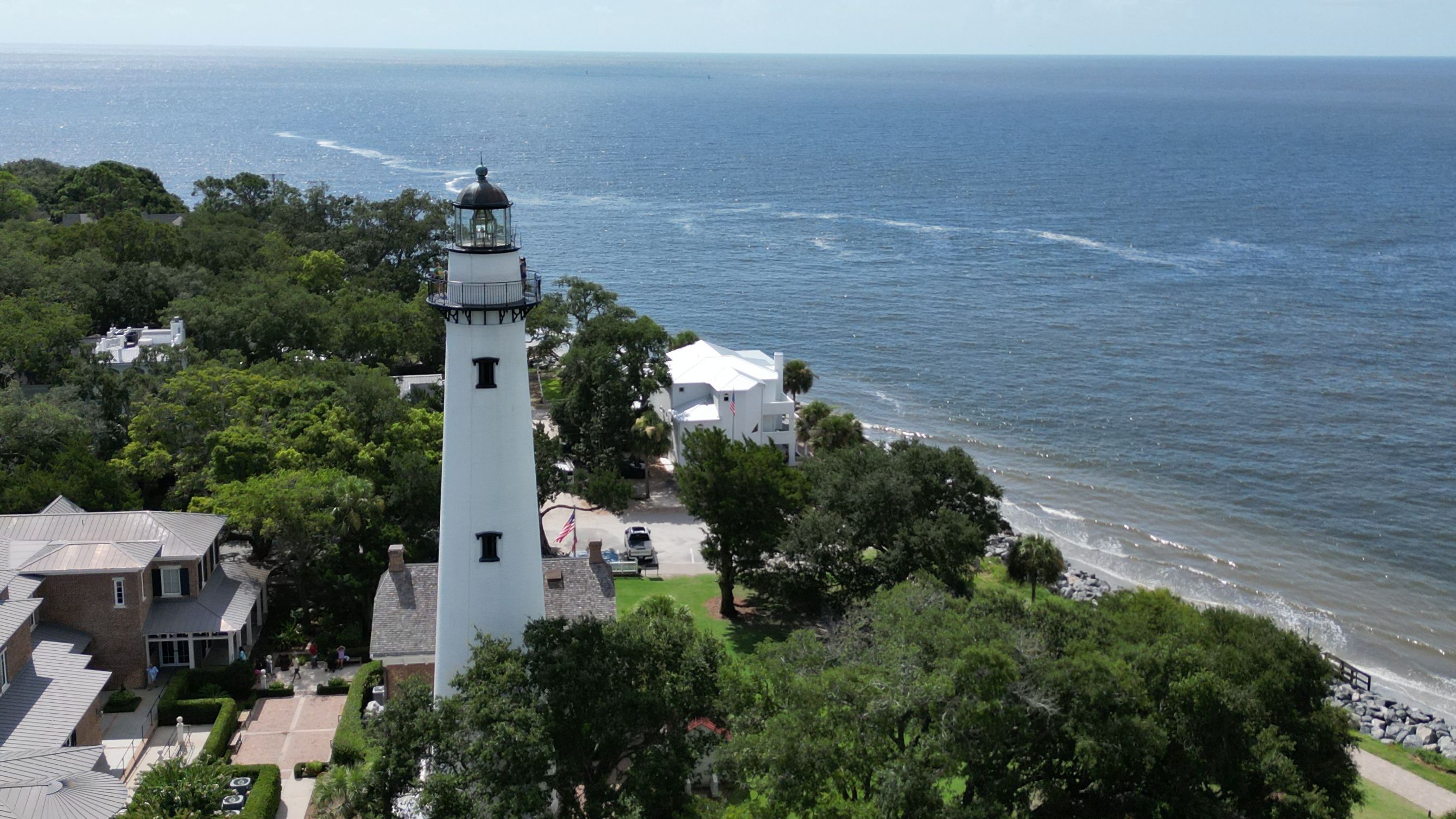 Aerial view of the St. Simons Island lighthouse and a beautiful beach on a sunny day