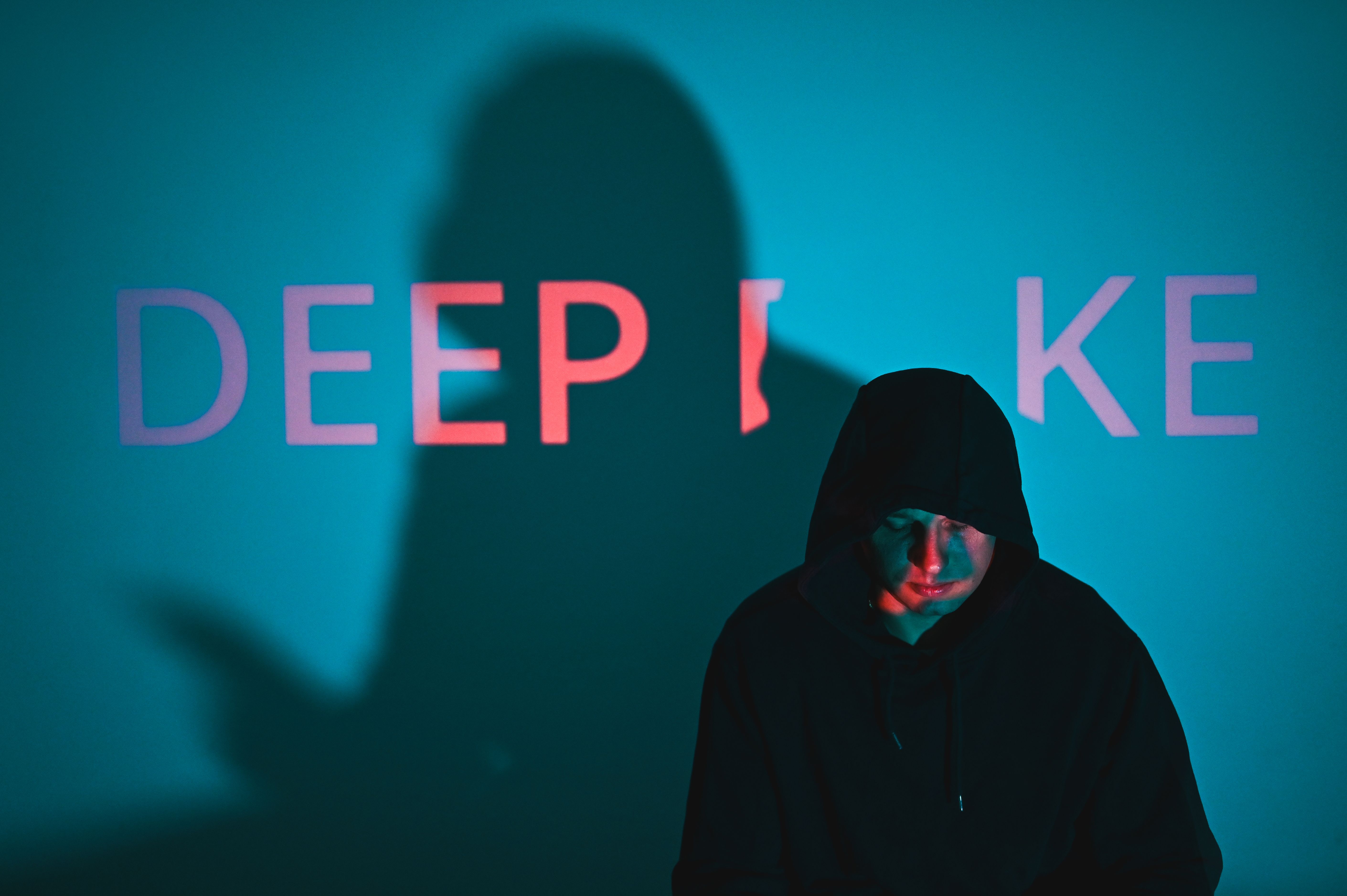 Hooded man standing with deepfake projection and shadow. wannacry ransomware attack