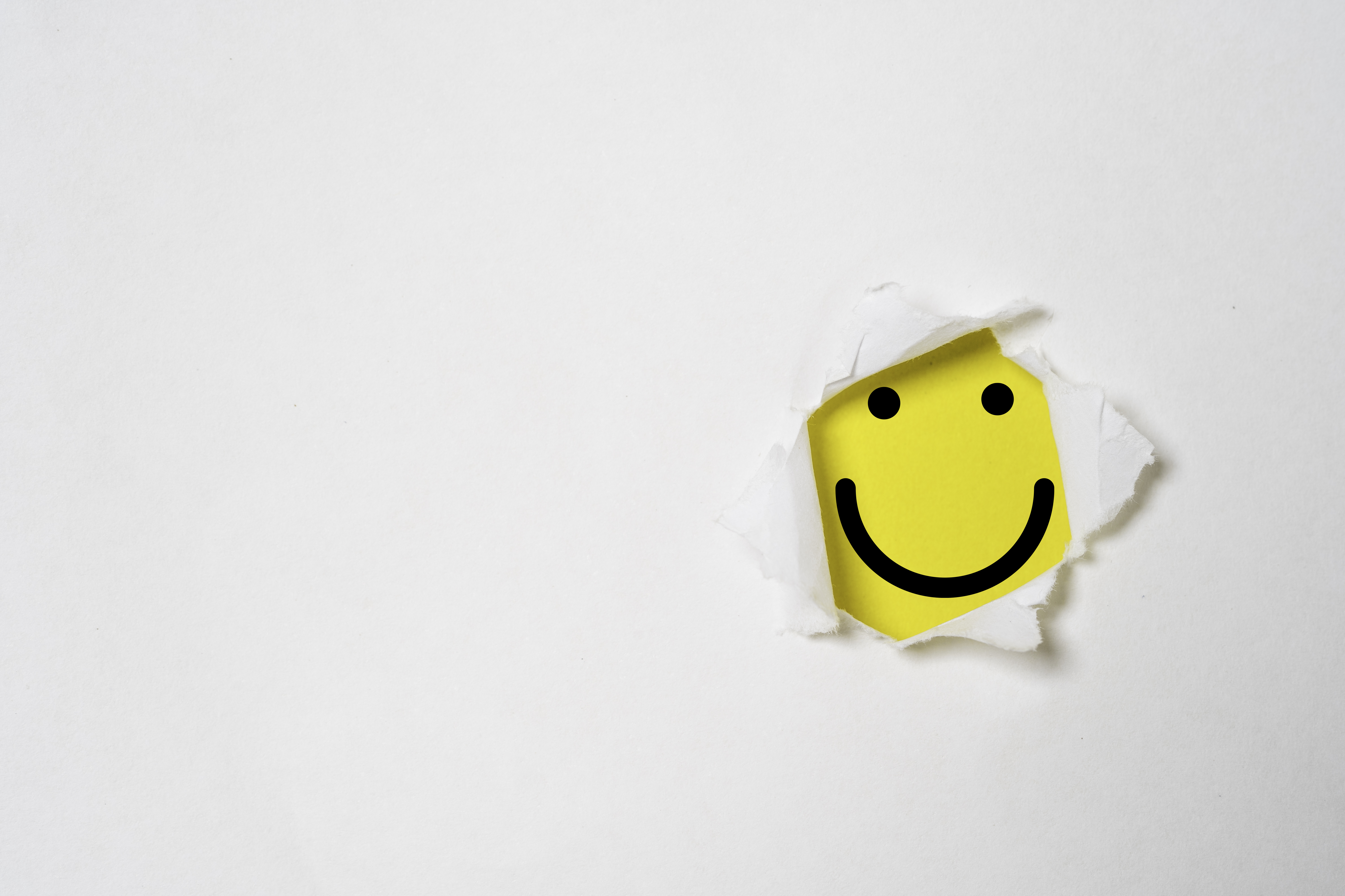 Smile face inside yellow background and white punch paper with copy space for positive mindset and client excellent evaluation concept , Customer experience and quality feedback concept.