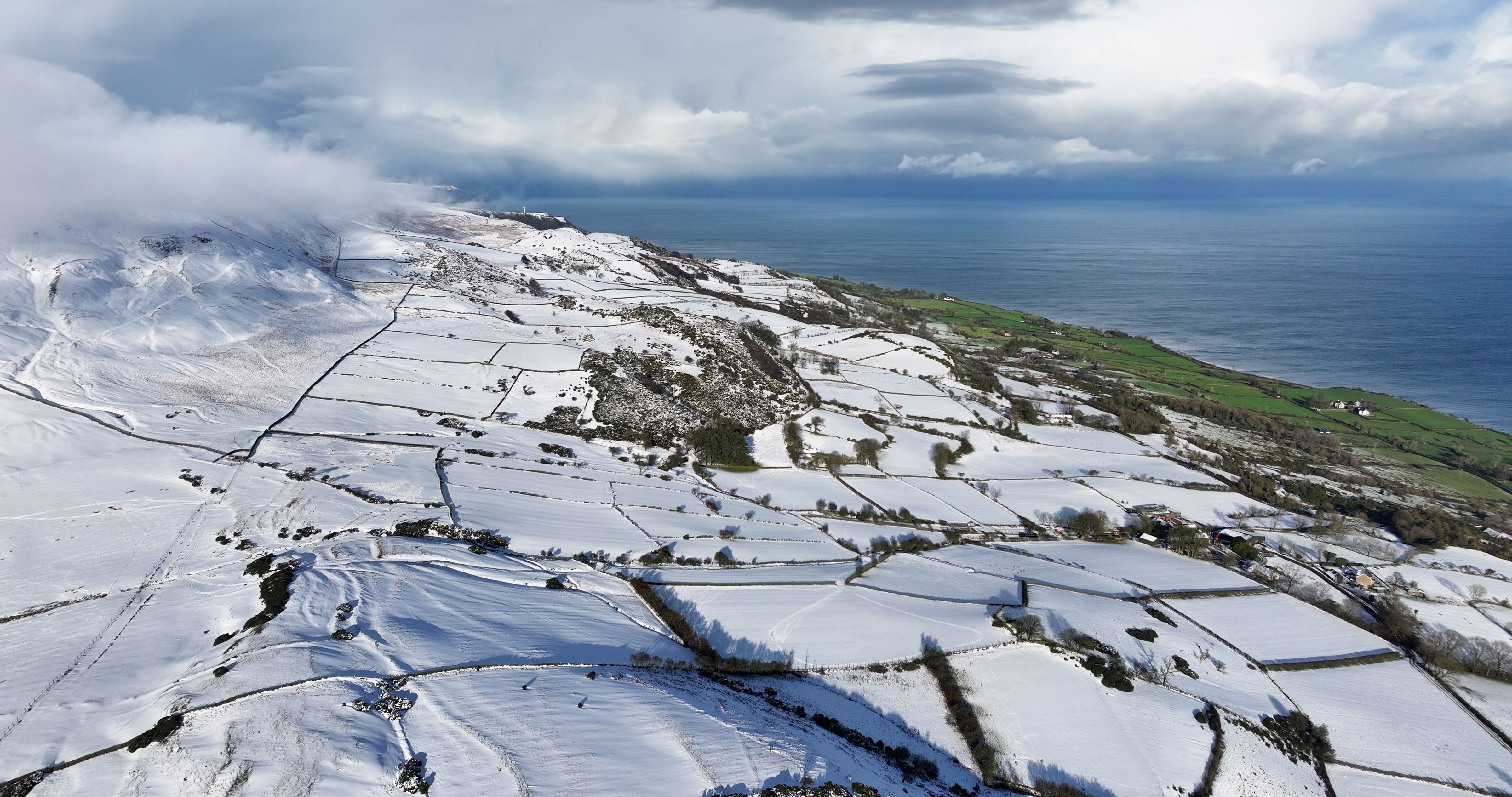Aerial view of freezing fog on the snowy beautiful and spectacular Rolling hills of the Glens of Antrim Northern Ireland