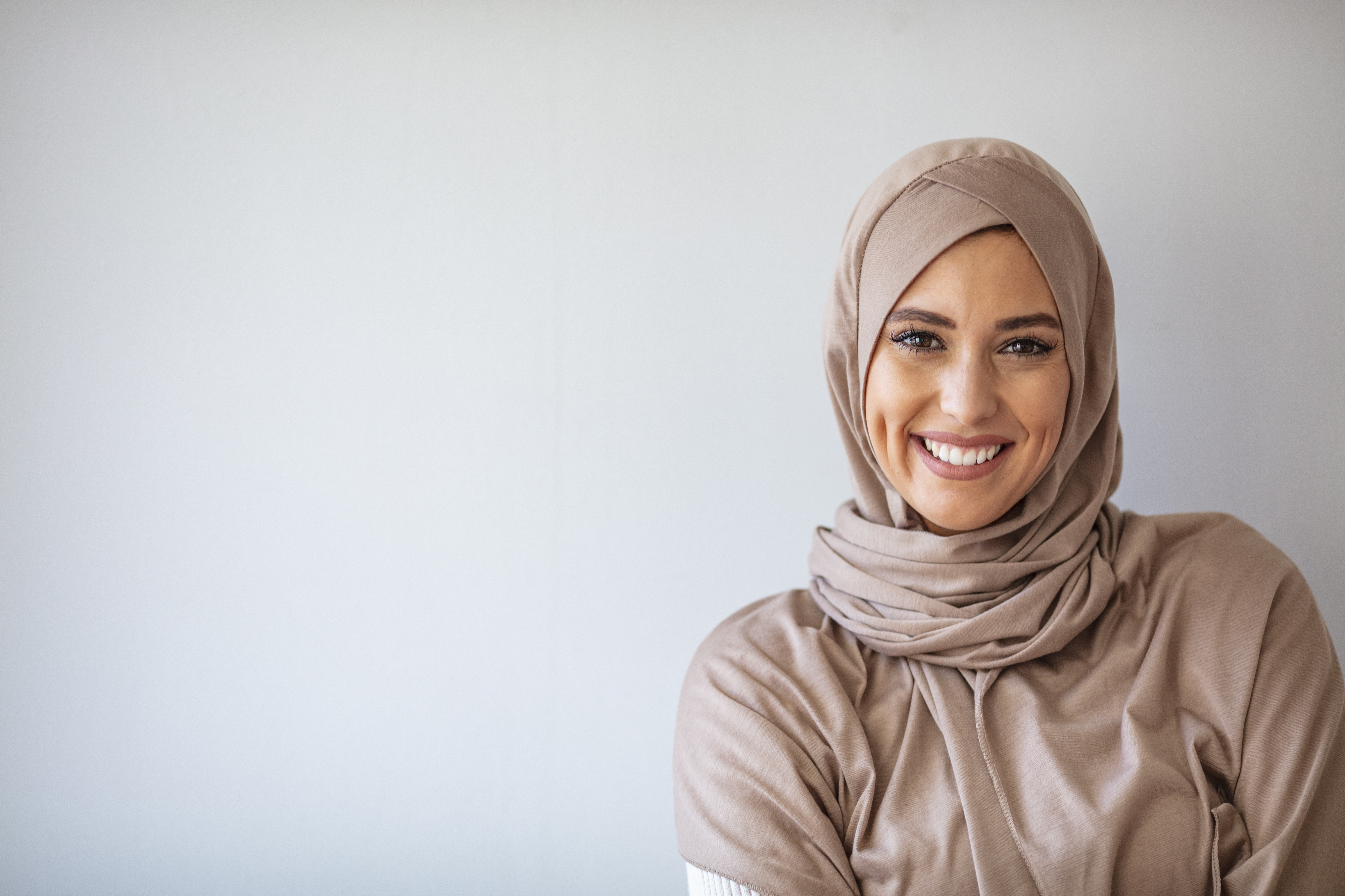 Portrait of beautiful Muslim woman on grey background.