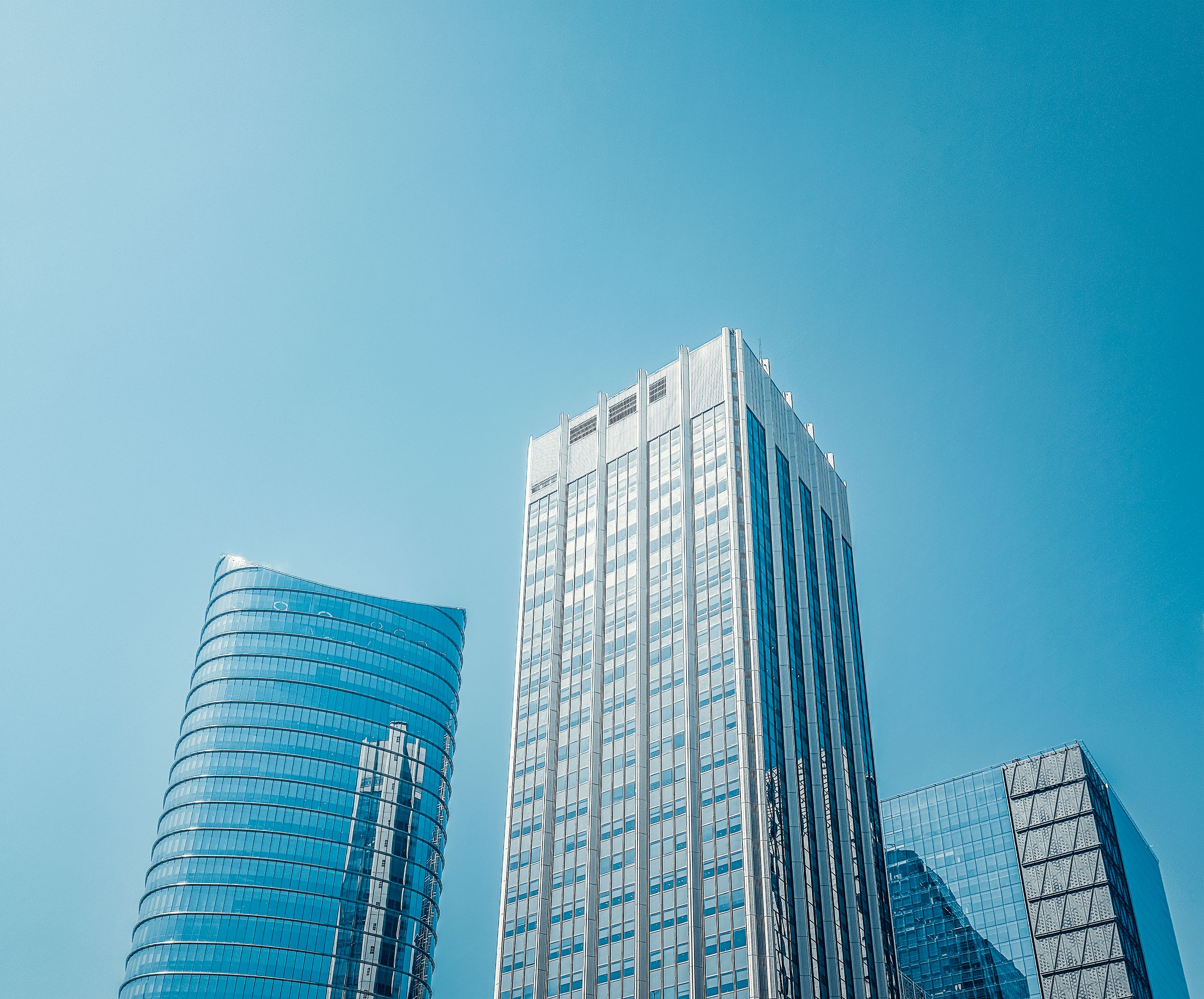 Three high-rise buildings with mirrored windows on a sunny day