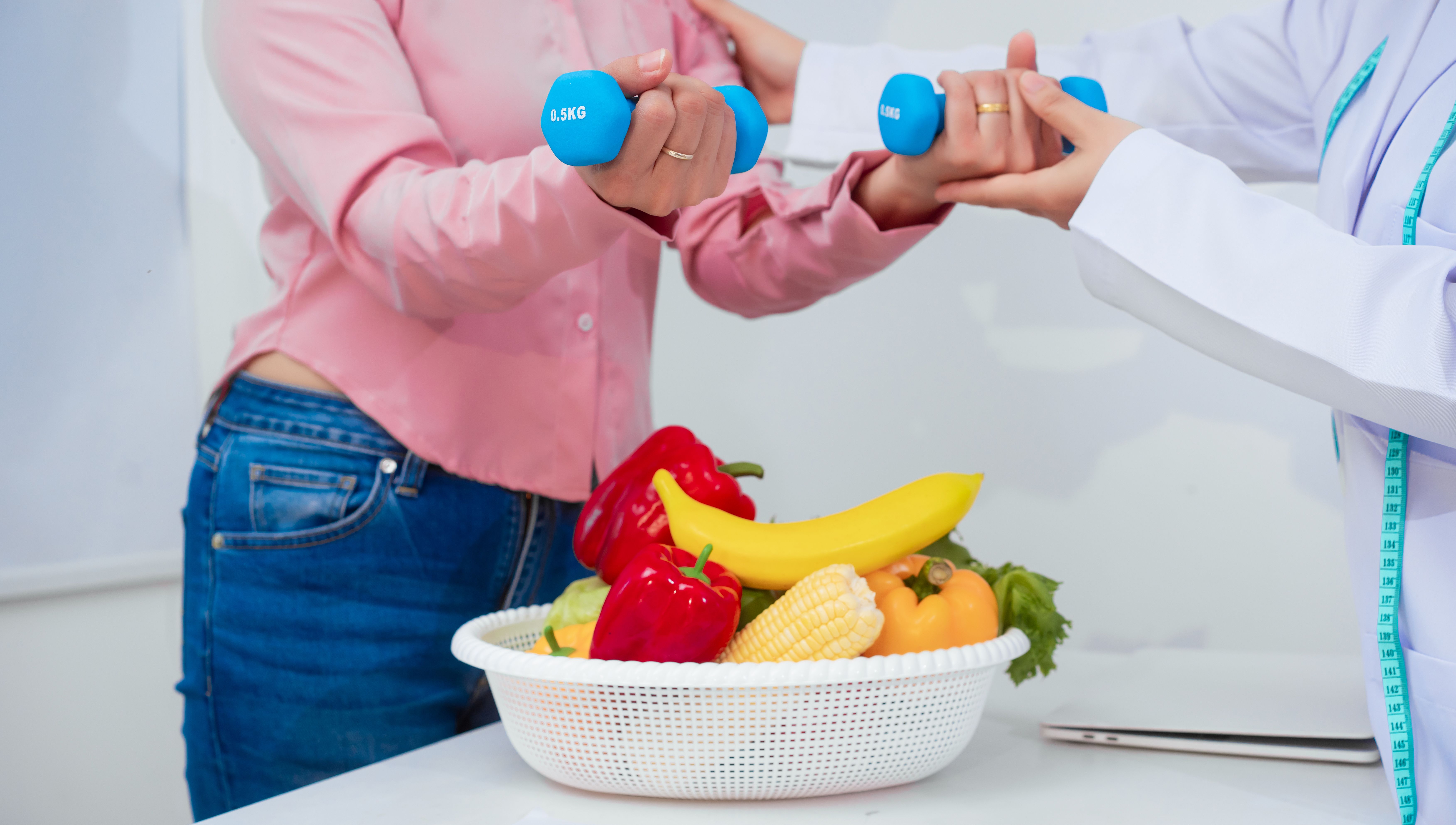 A middle aged Asian female nutritionist consults with a middle aged Asian female patient at a table, discussing nutrition, healthy eating, exercise, and lifestyle changes for weight loss and health A middle aged Asian female nutritionist consults with a middle aged Asian female patient at a table, discussing nutrition, healthy eating, exercise, and lifestyle changes for weight loss and health
