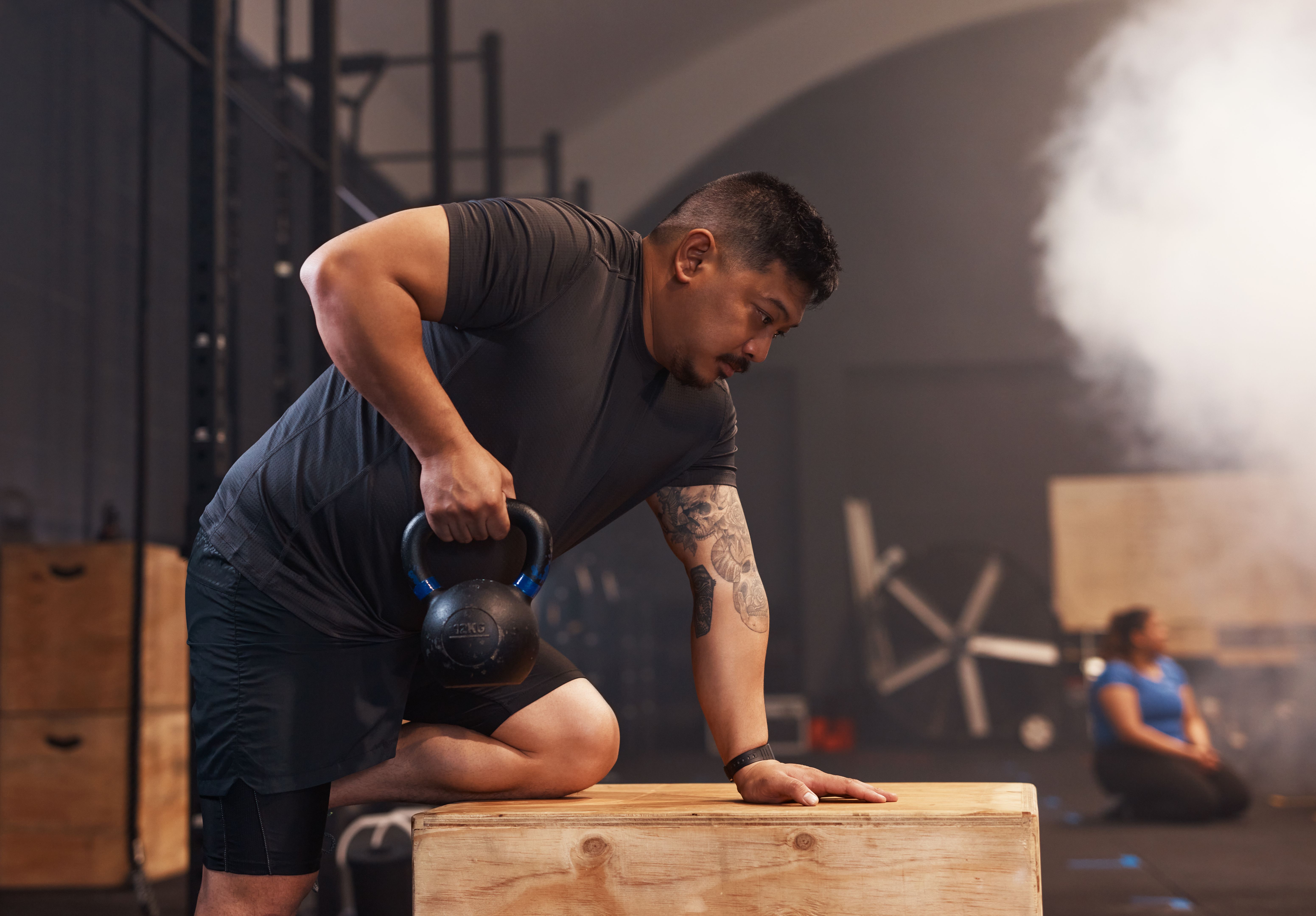 Shot of a young man working out with weights in a gym