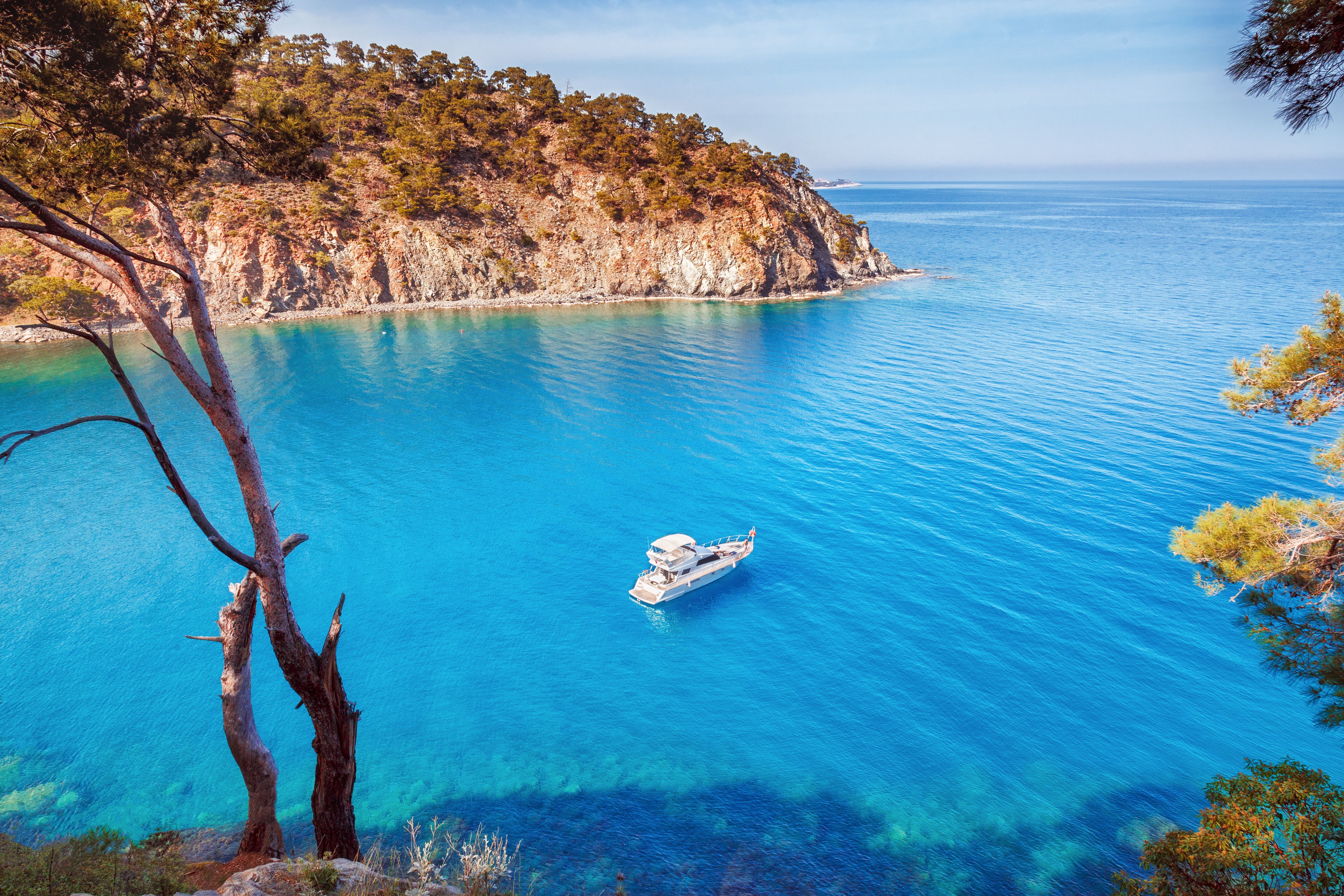 Picturesque scenery of coastline of Turkey on Mediterranean sea. Solitary luxury white yacht in the incredible bay. Summer vacation background. Location Antalya Turkey.