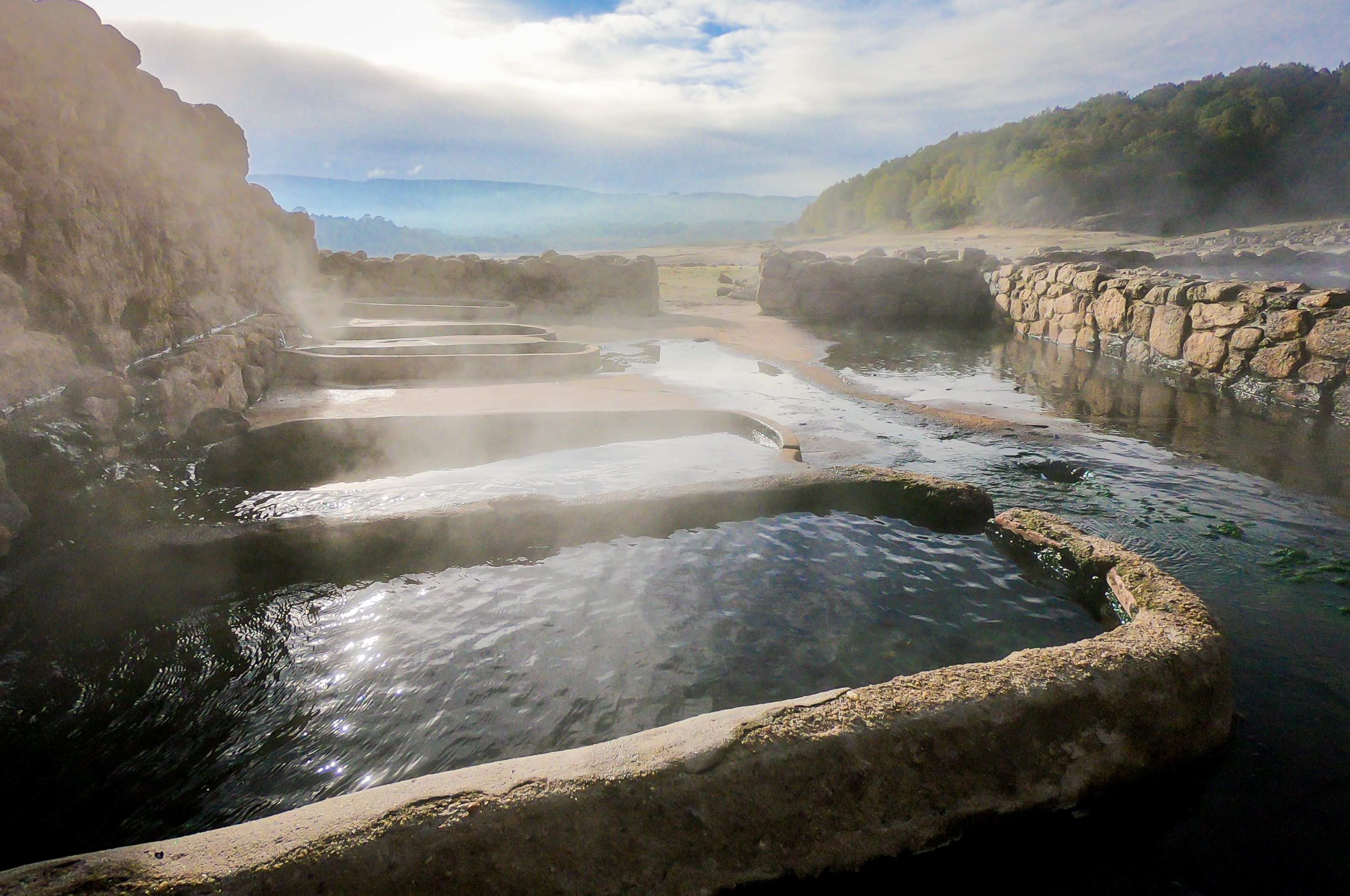 Natural Roman baths outdoors with hot steam and thermal water.