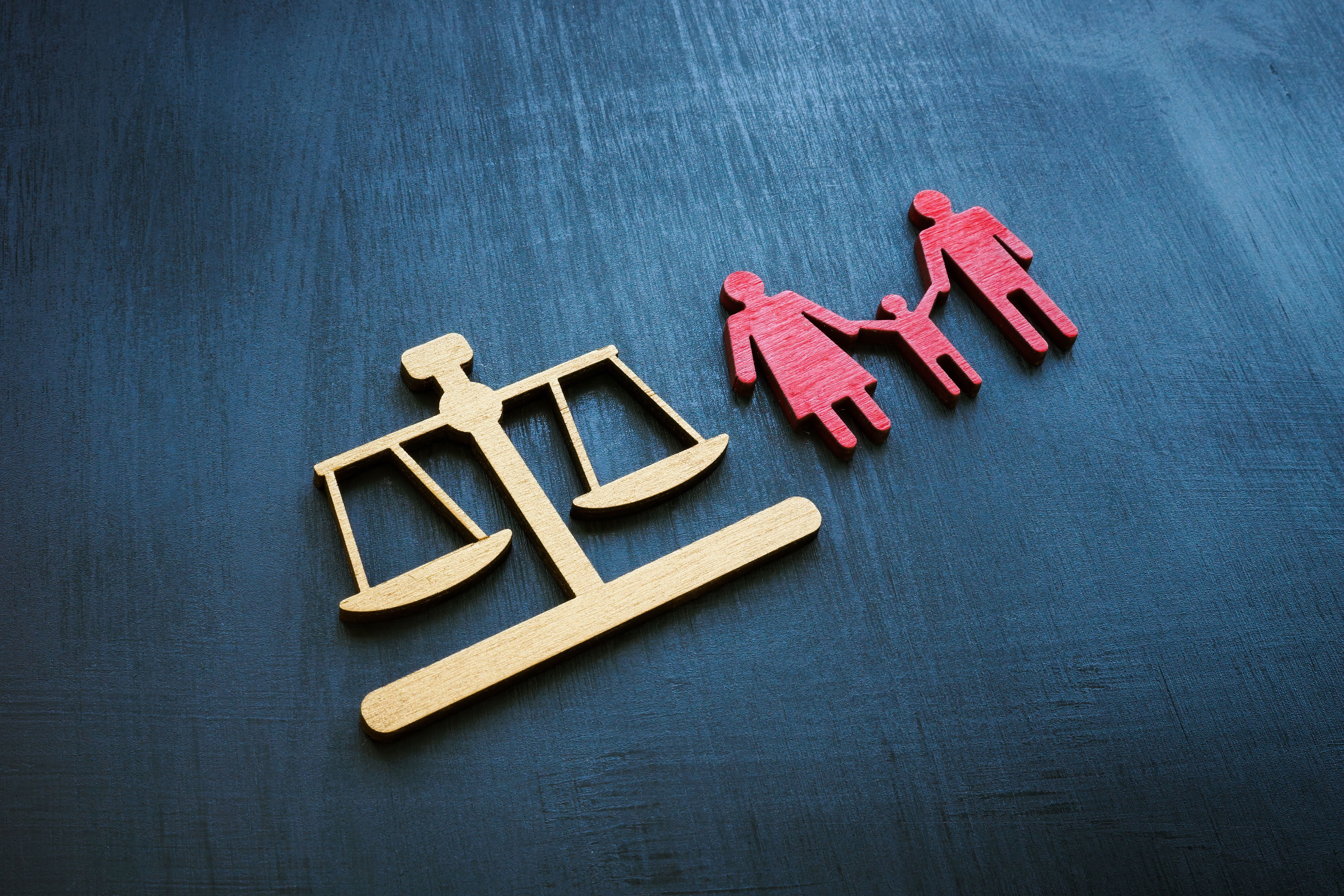 Family law concept. Figures of scales and families for adoption.