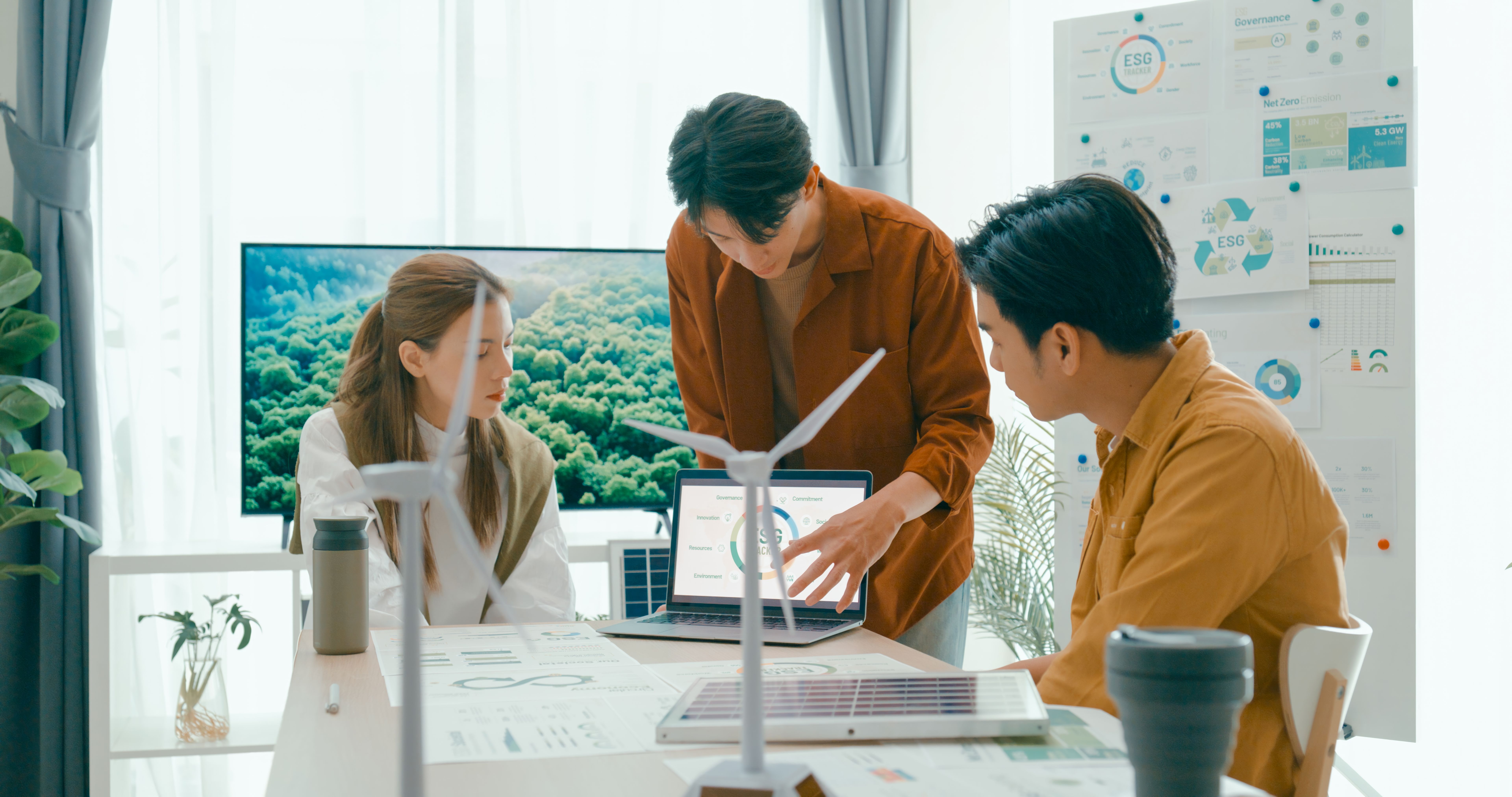 Diverse team engaged in meeting about environmental social corporate governance, highlighting sustainability strategies and goals. Eco-Friendly Business Team Discussing ESG Goals.