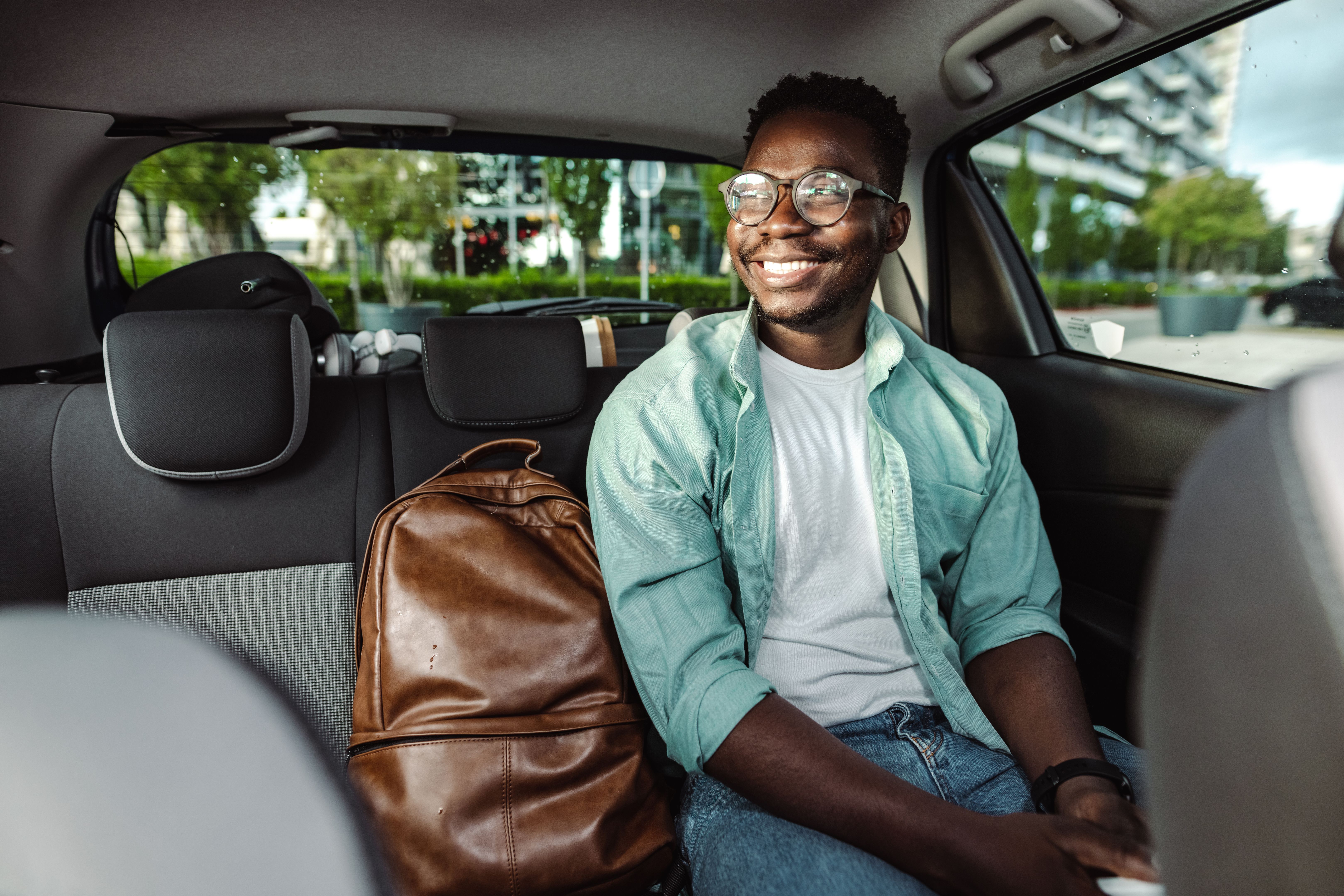 African-American man sitting at the back seat of a taxi