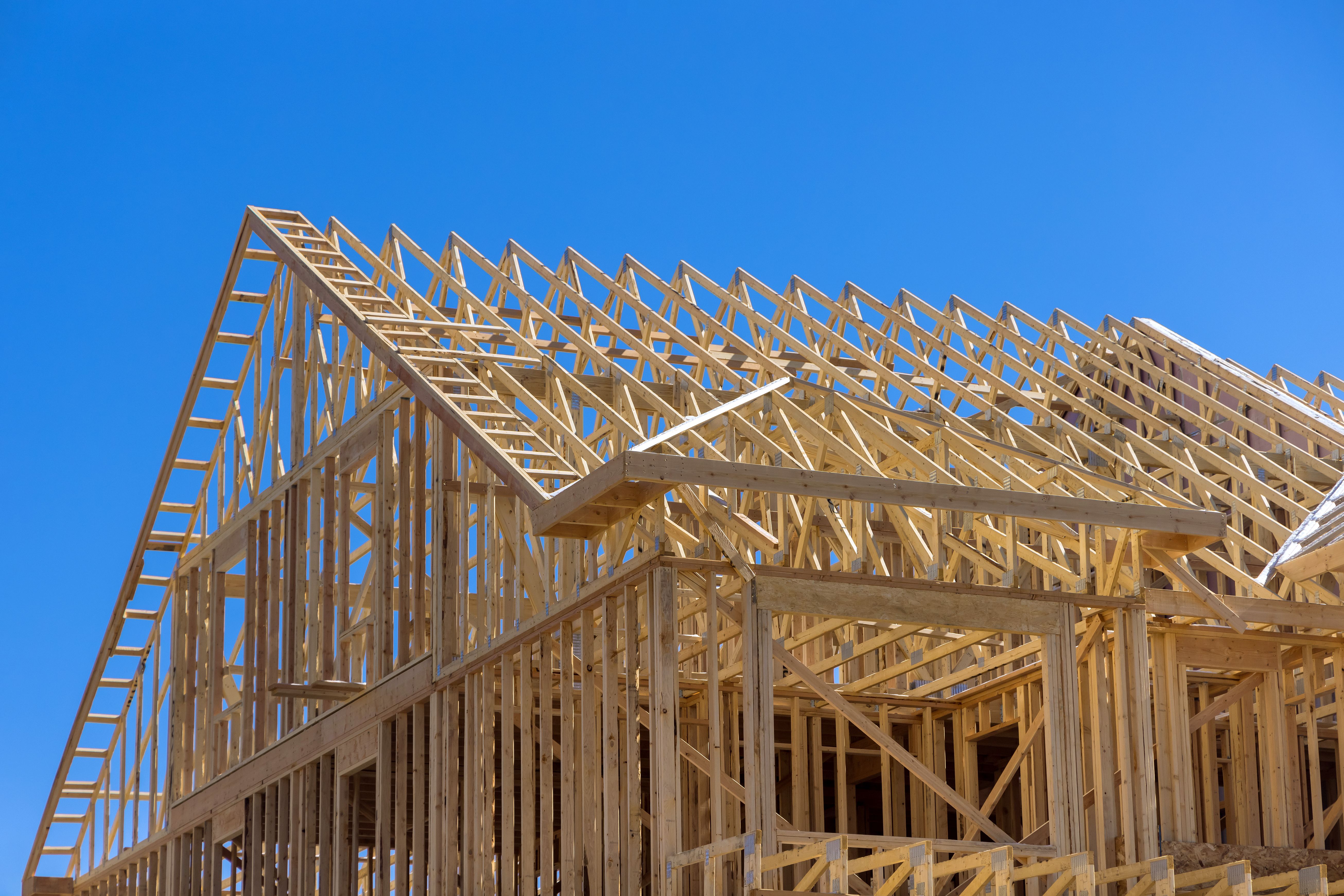 Framing wood beams of wooden building new stick built home under construction