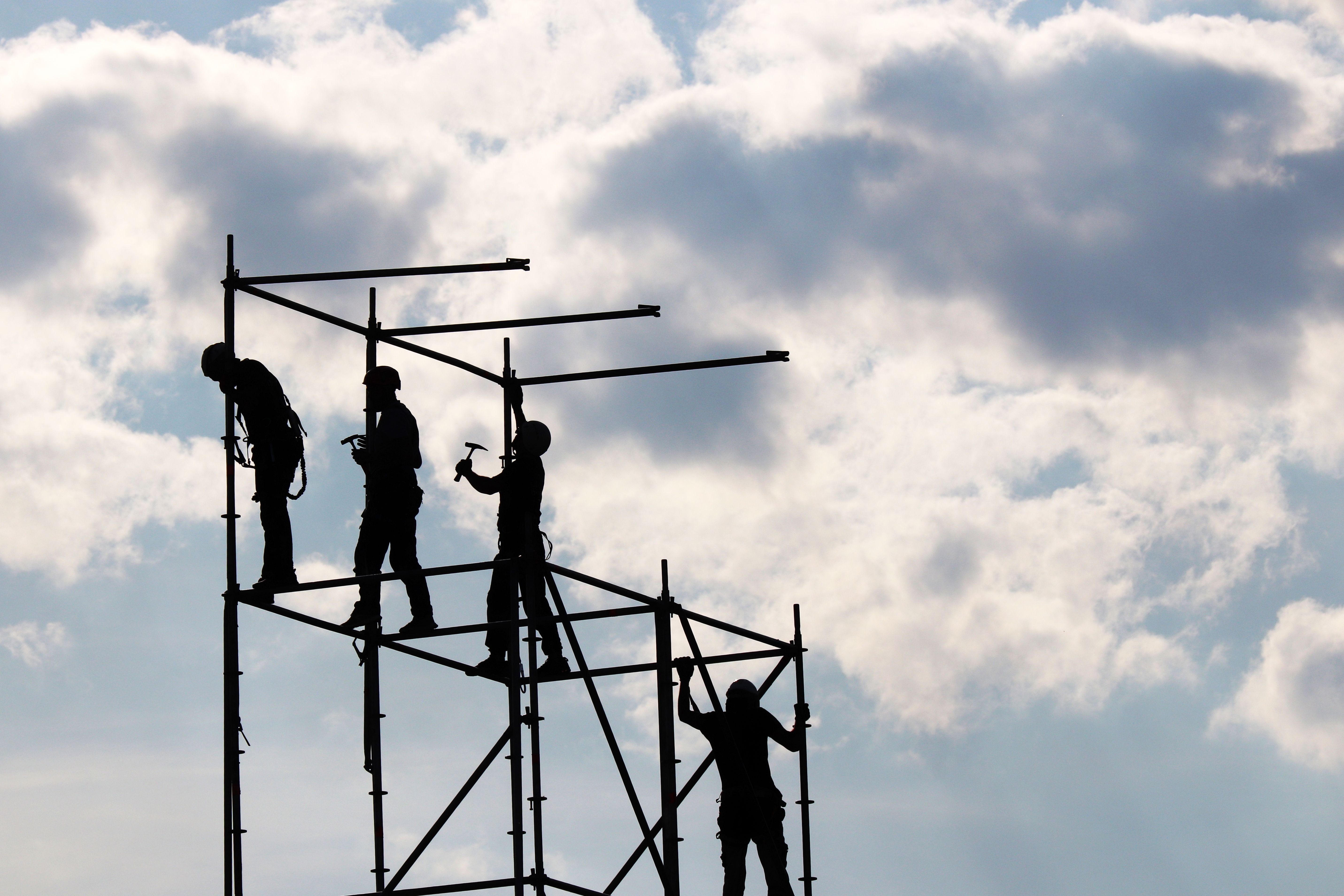 Construction workers on scaffolding Construction workers on scaffolding