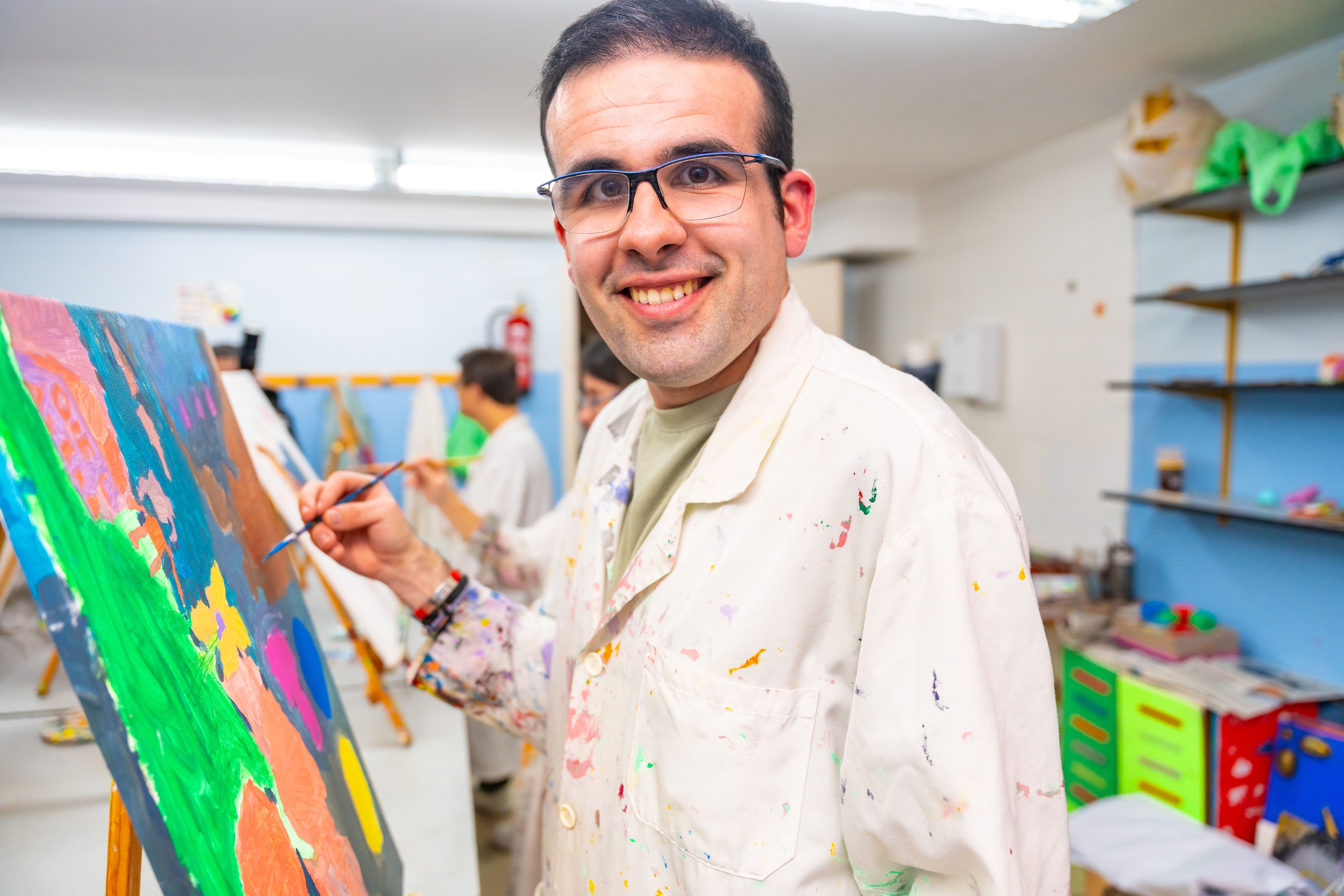 Disabled man happy while painting on canvas
