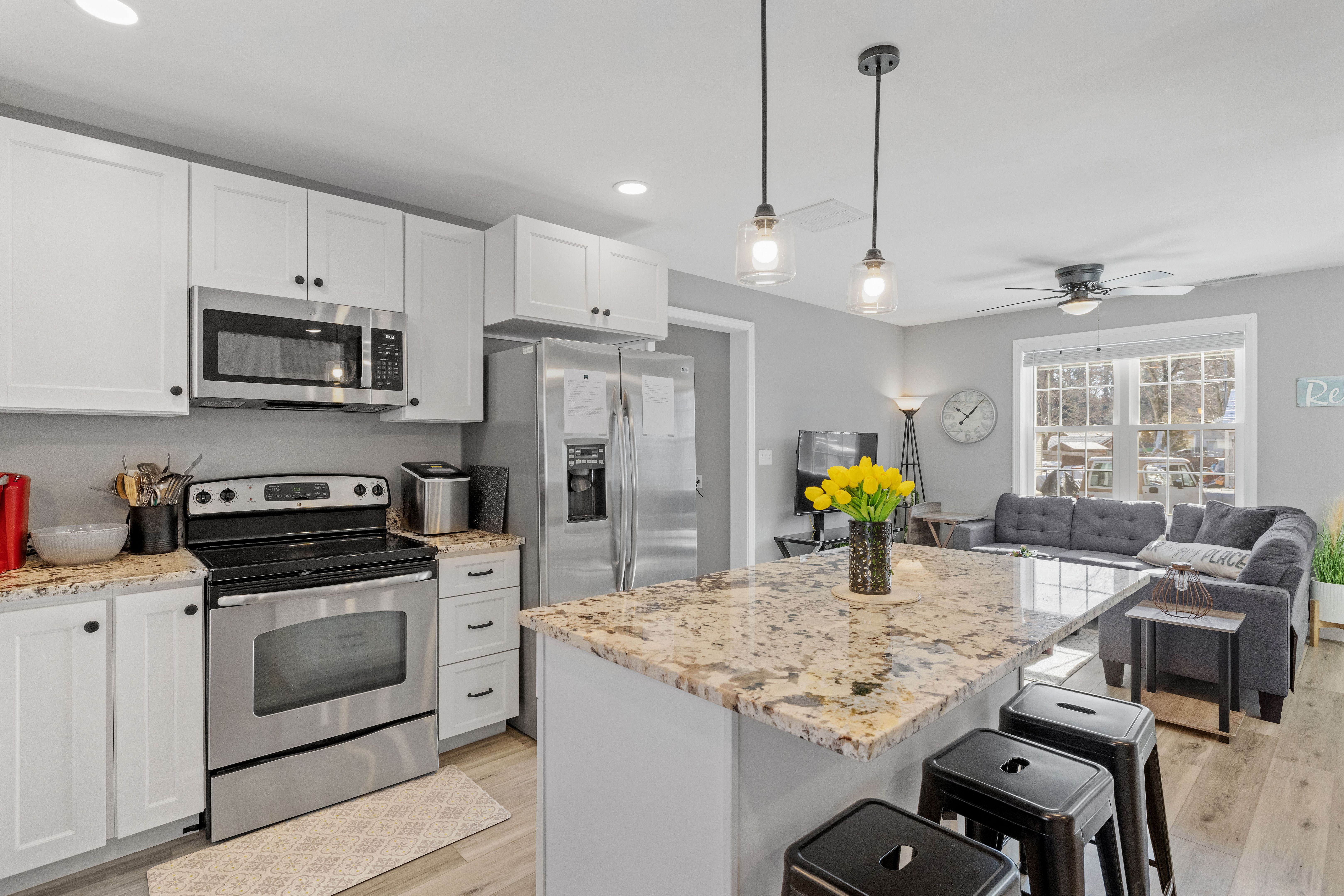 Modern kitchen with white walls and cabinets, featuring stainless steel appliances