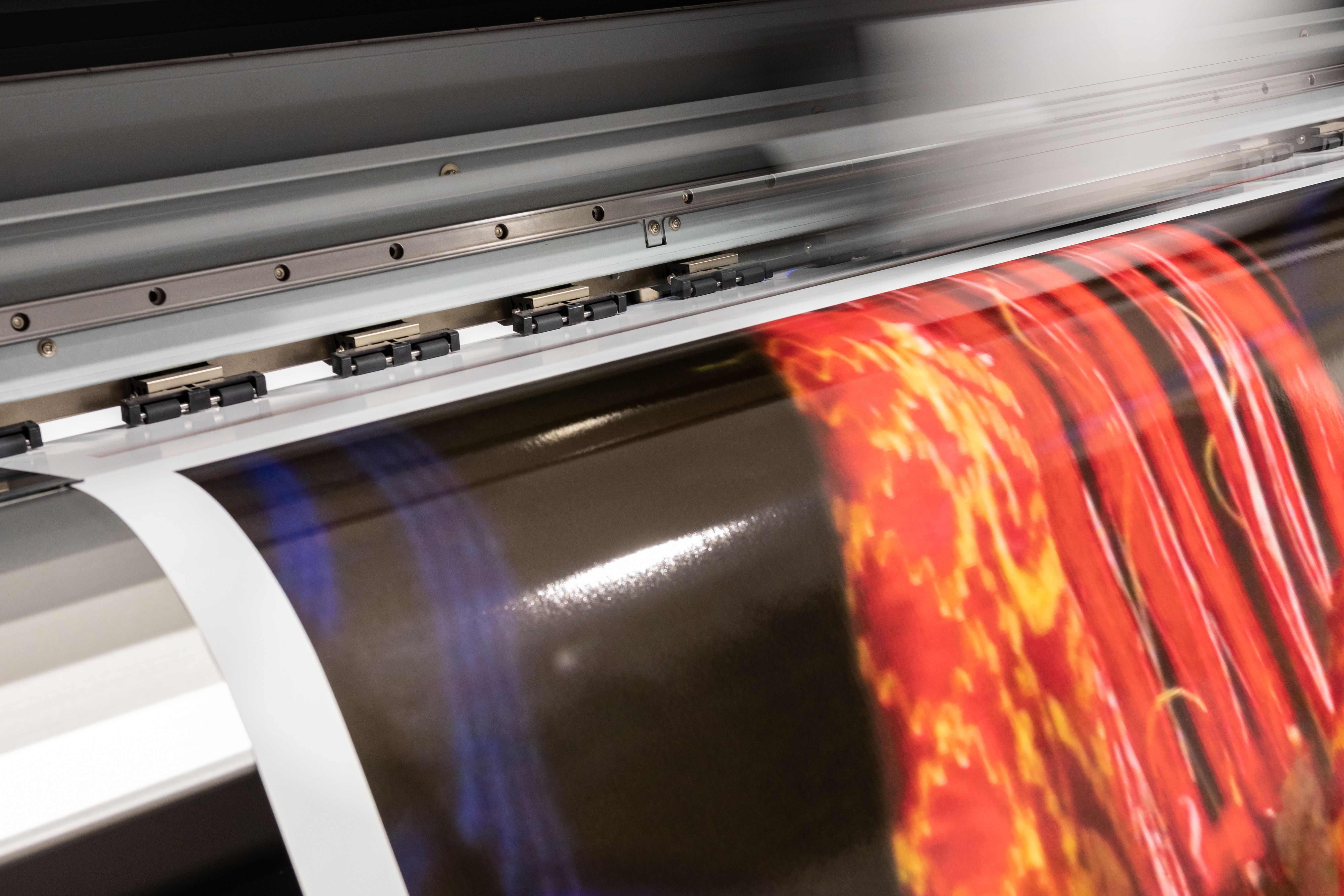 Big printer in professional facility during color sampling test. Indoor, industrial activity.