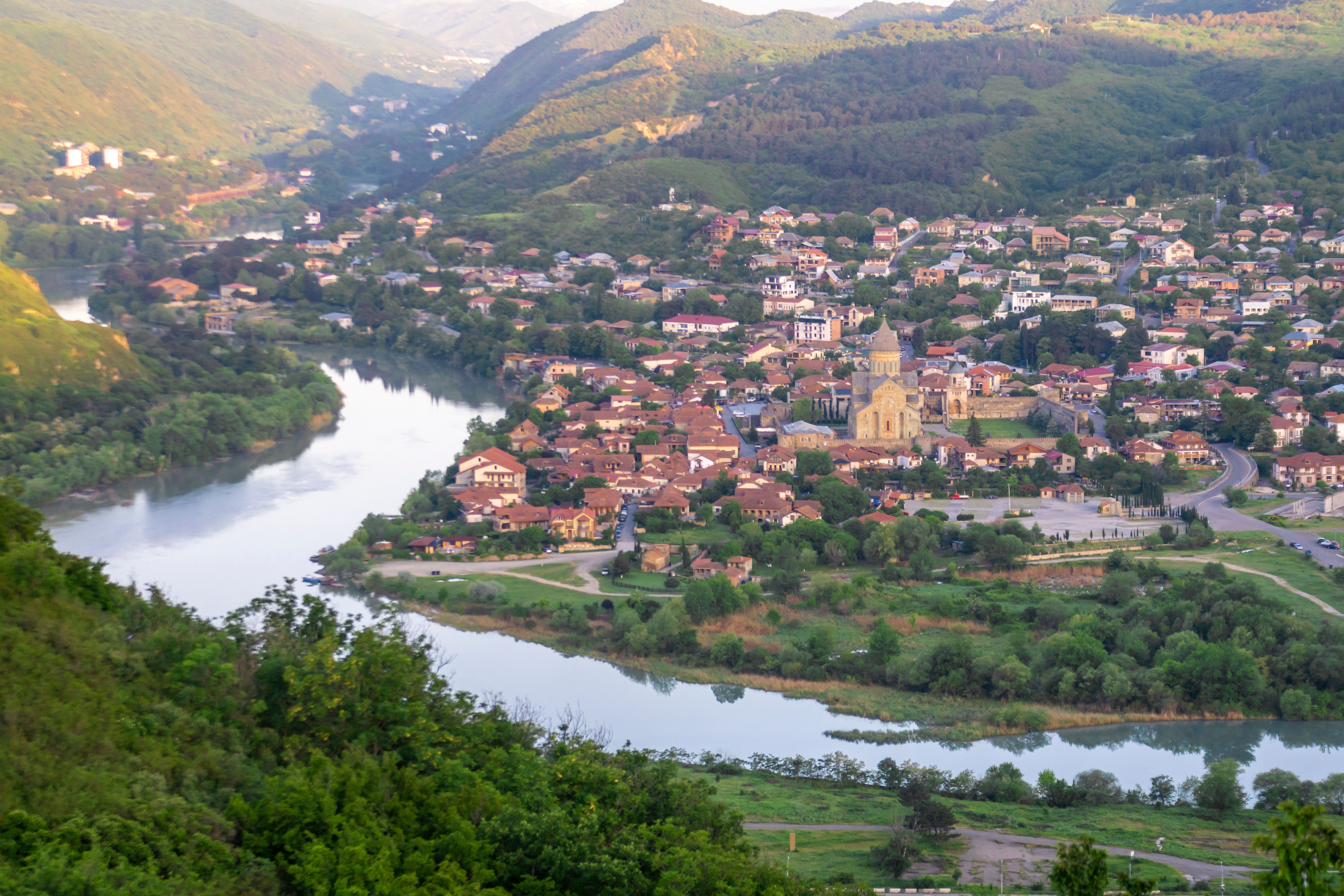 Morning view of Mtskheta city and Svetitskhoveli cathedral. Sunlight on the mountains. Confluence of the Aragvi and Kura rivers