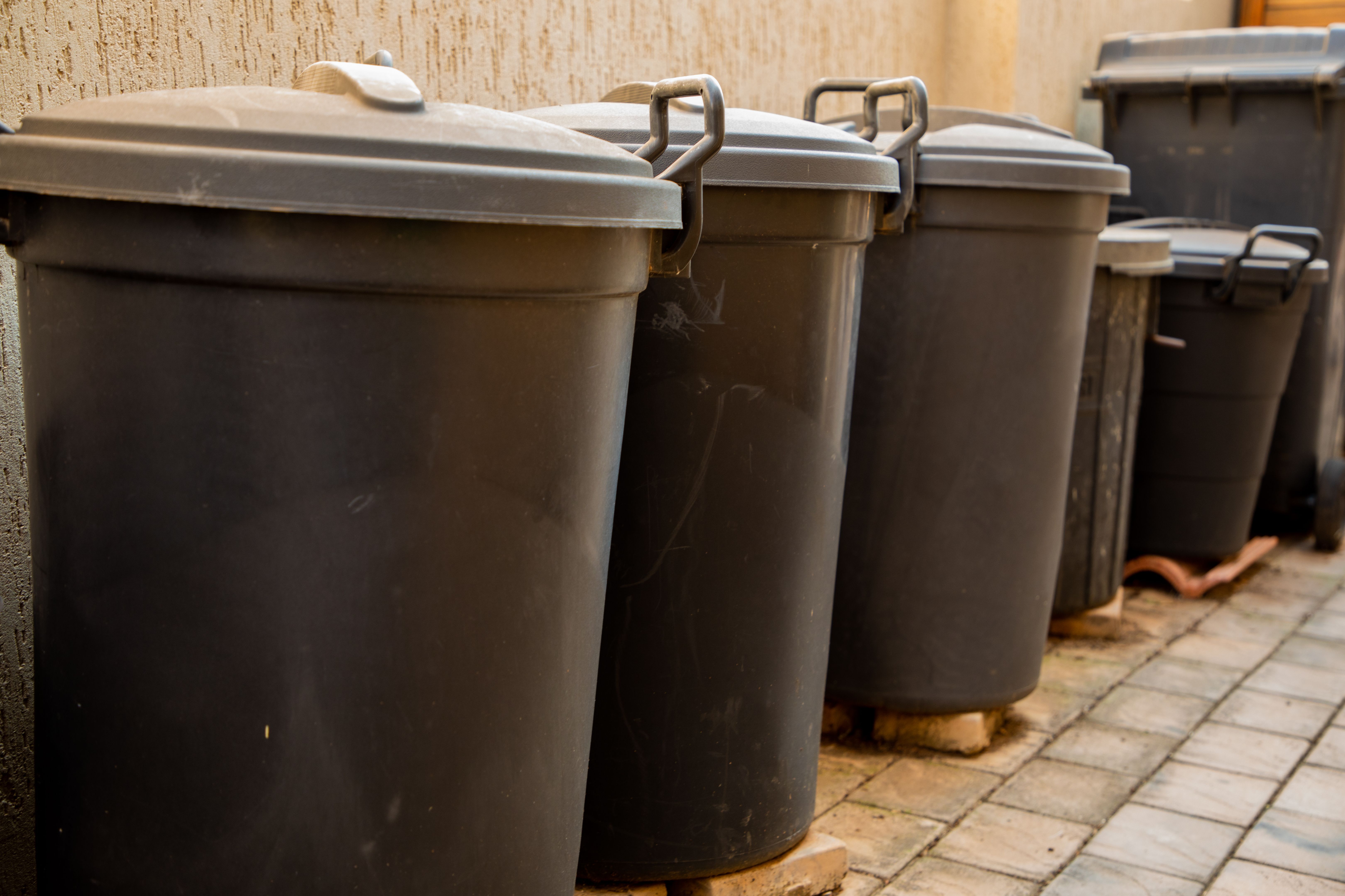 Selection of different black plastic trash bins.