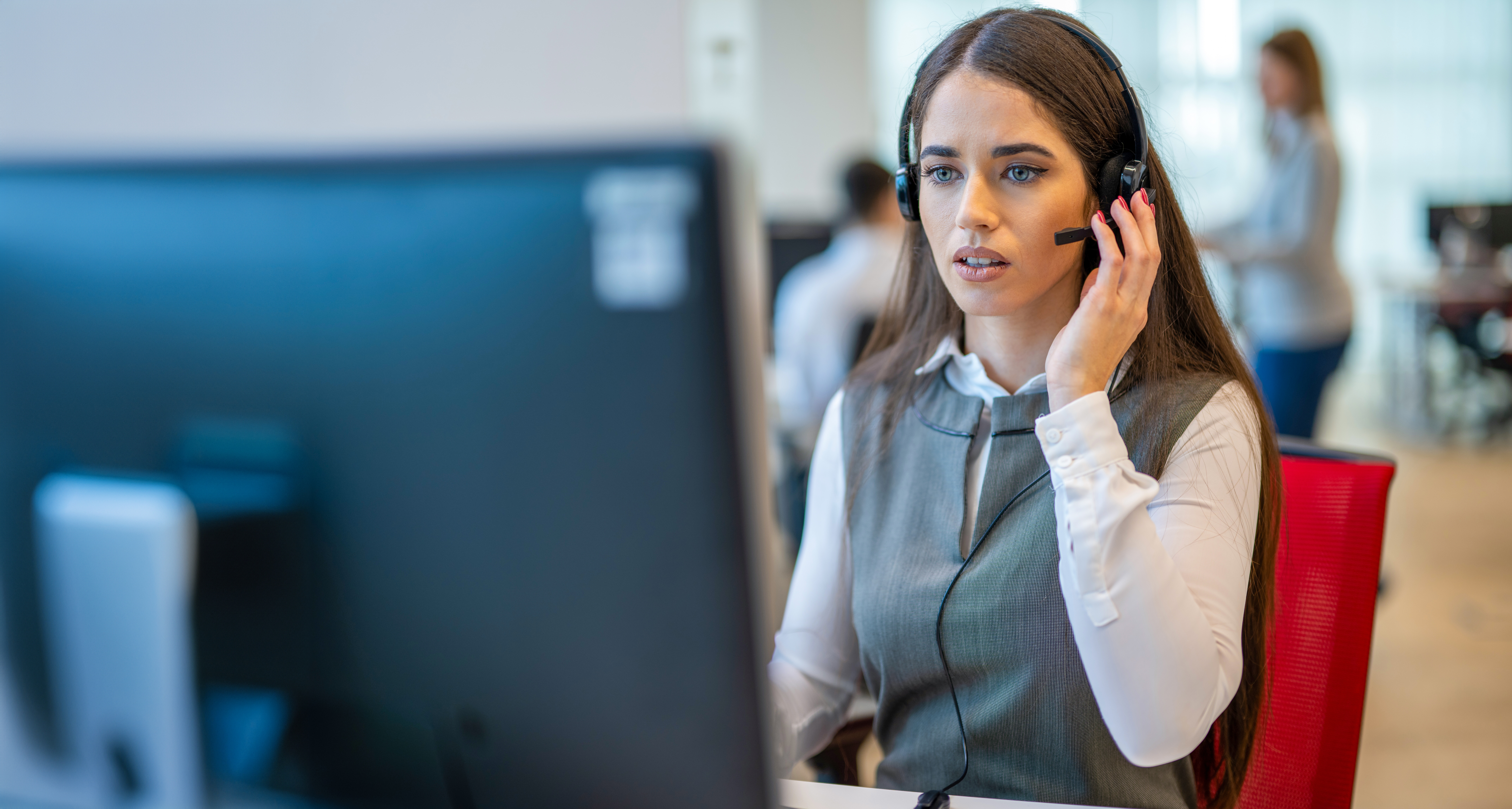 Frustrated woman working in a call center on computer.