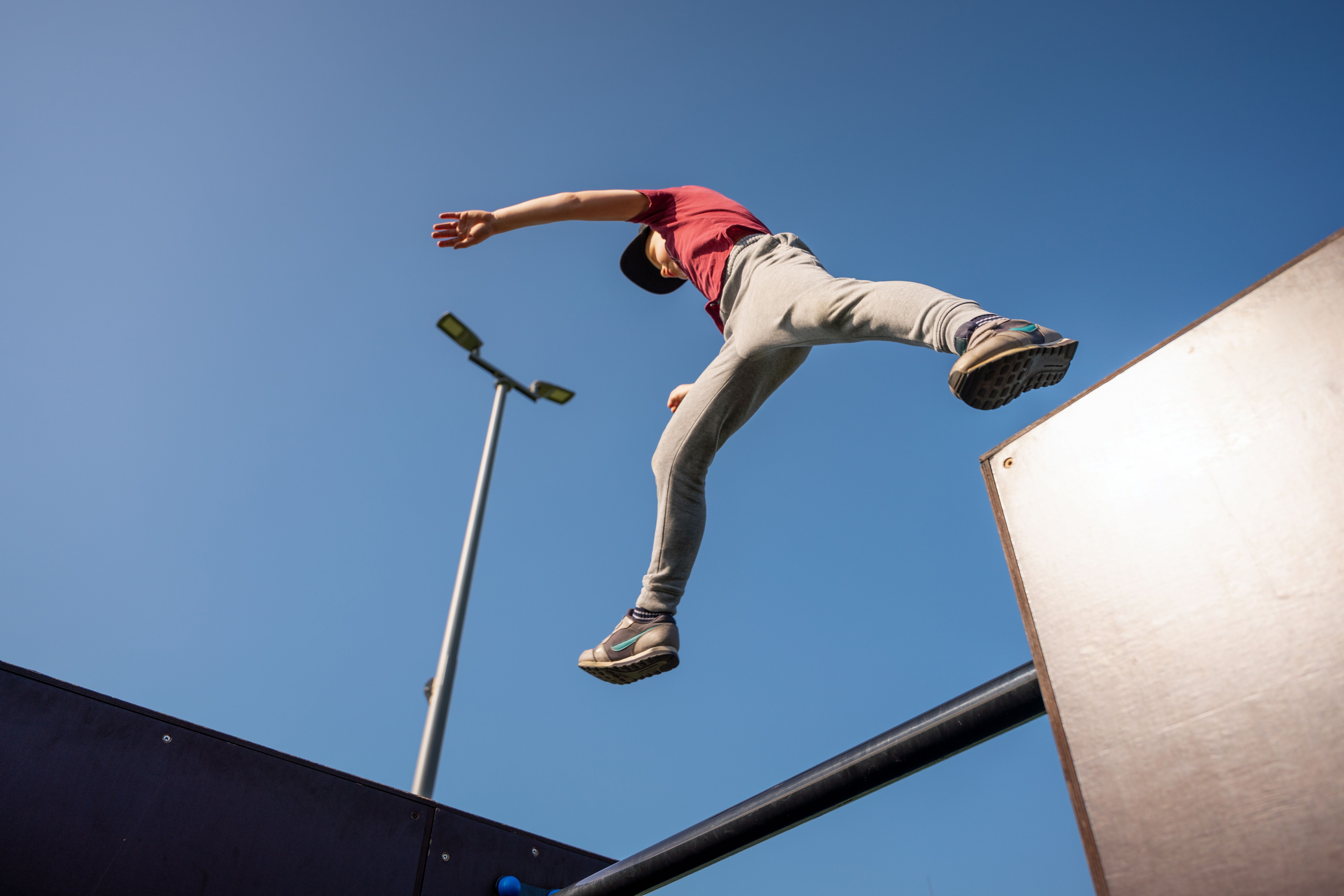 Boy jumping at free running sports ground in the morning