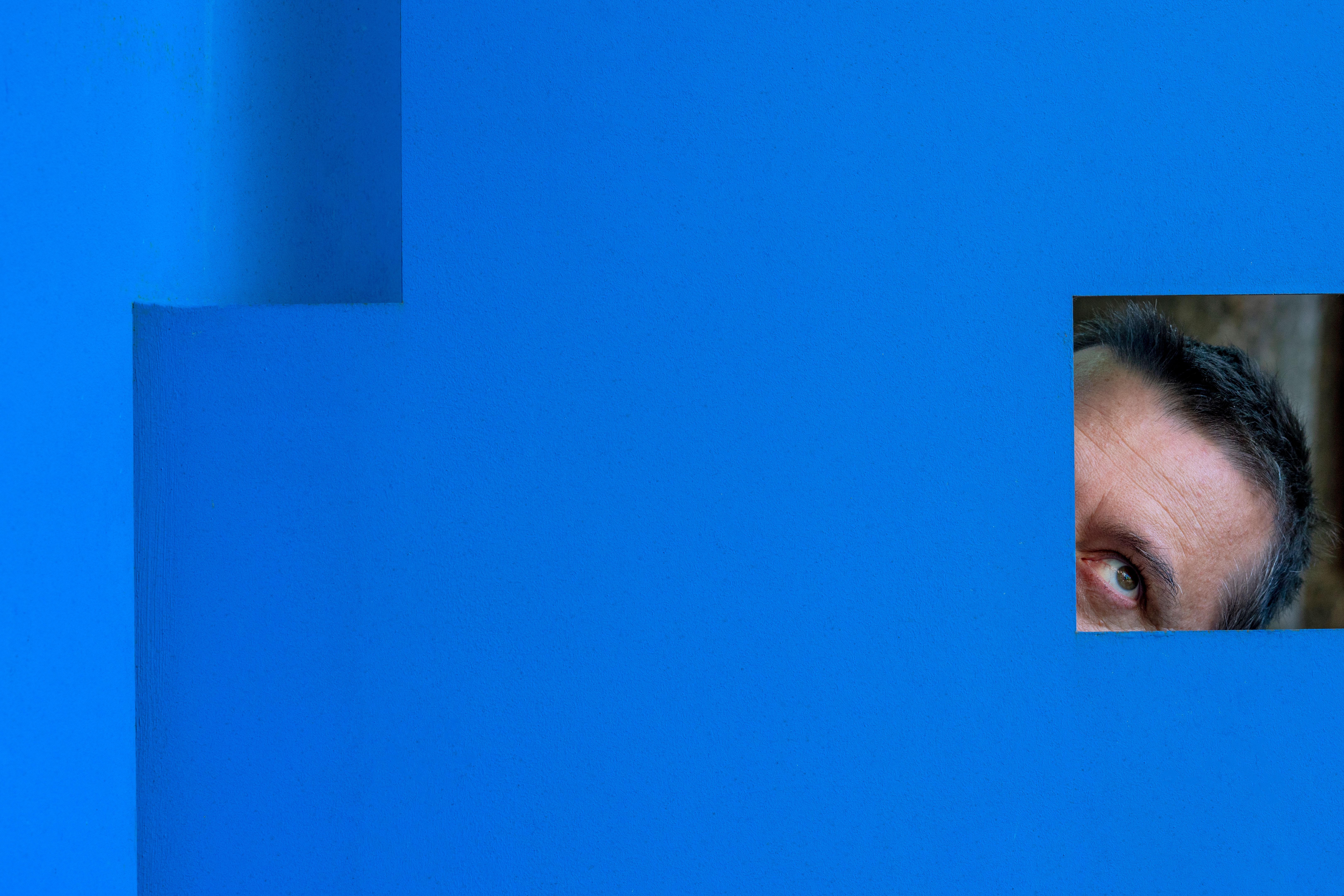 Extreme Close Up Portrait Of Mature Man Looking Though Blue Quadrilateral Frame Extreme Close Up Portrait Of Mature Man Looking Though Blue Quadrilateral Frame