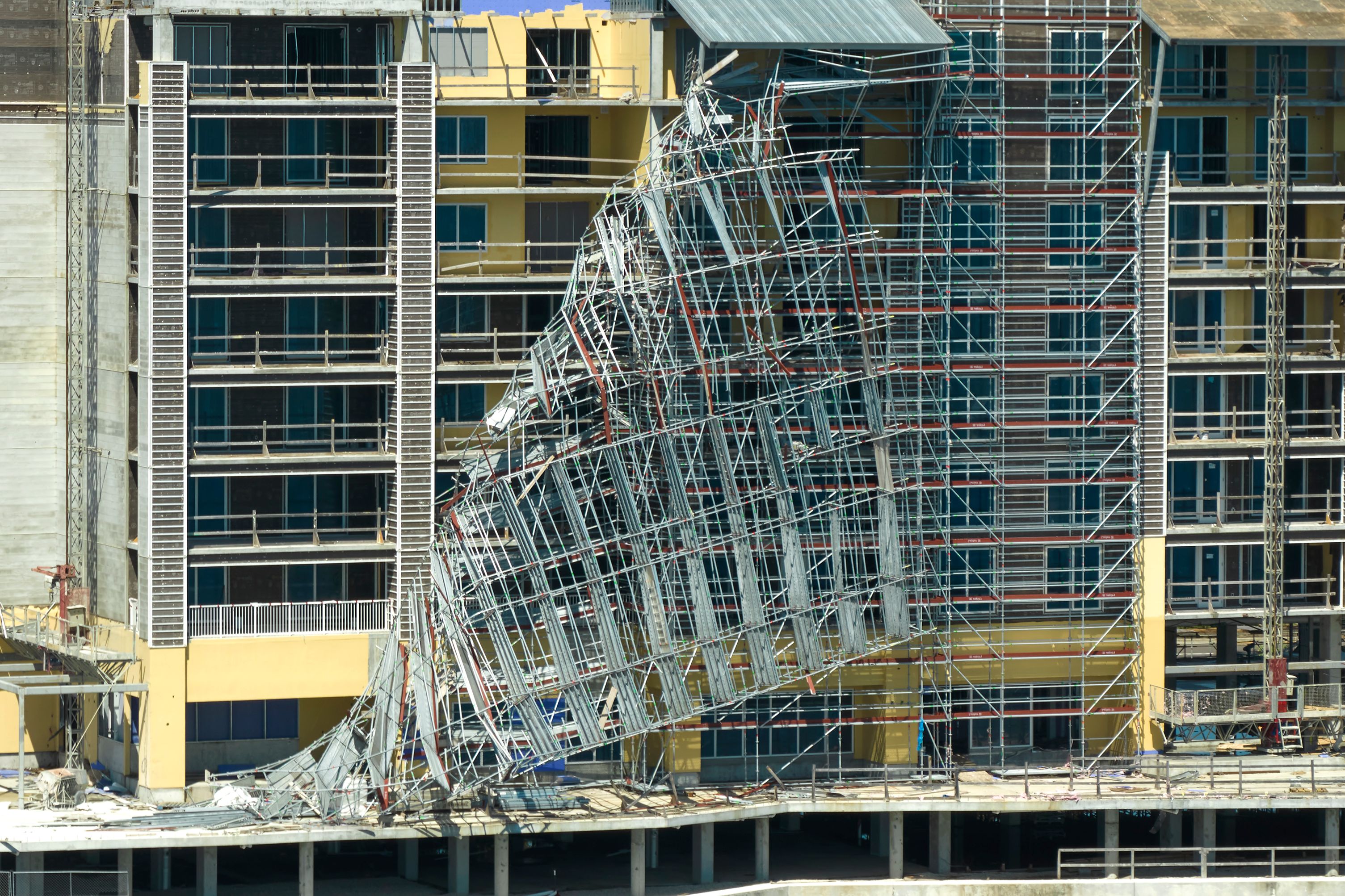 Aerial view of ruined by hurricane Ian construction scaffolding on high apartment building site in Port Charlotte, USA