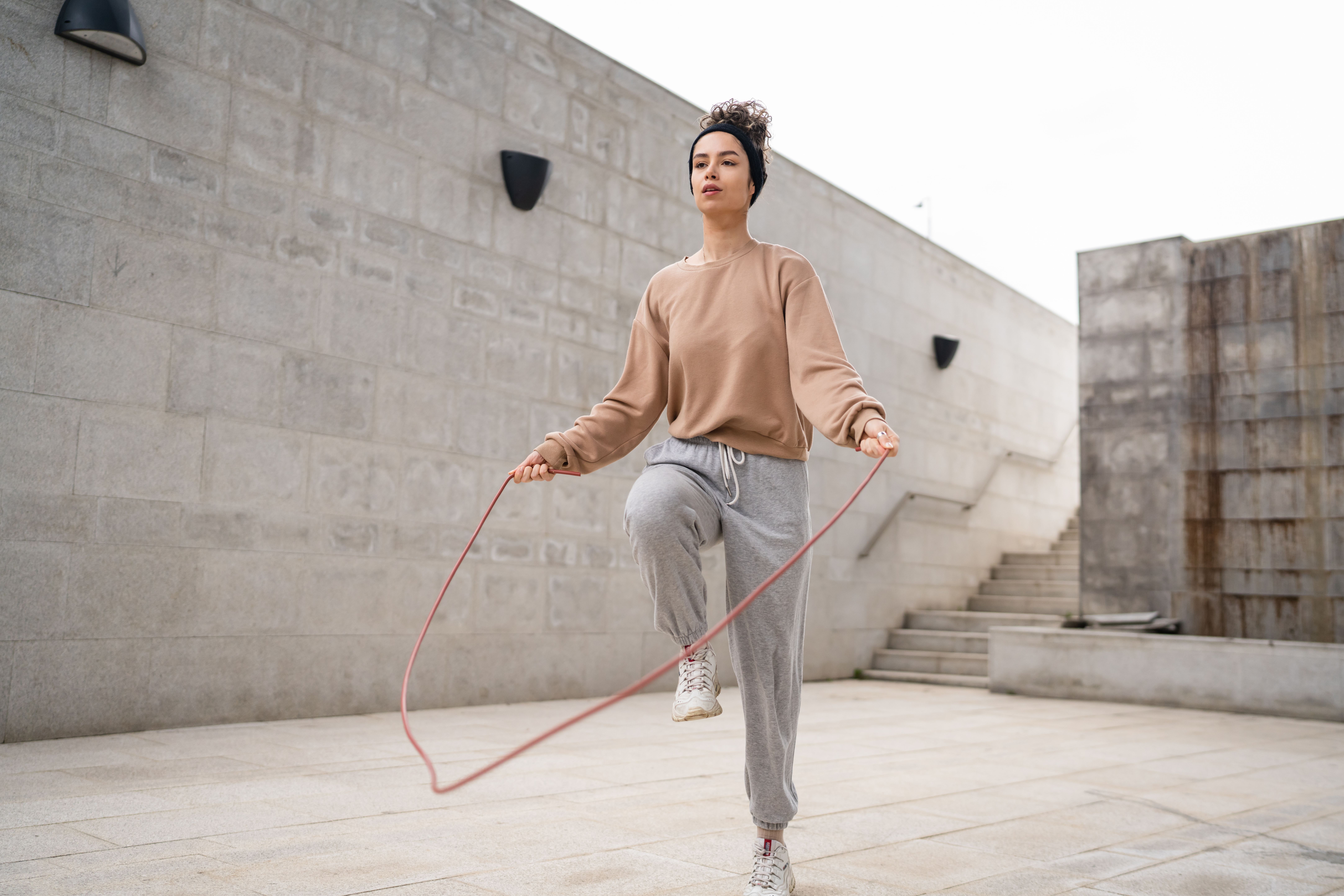one woman young adult caucasian female with jumping rope training one woman young adult caucasian female with jumping rope training