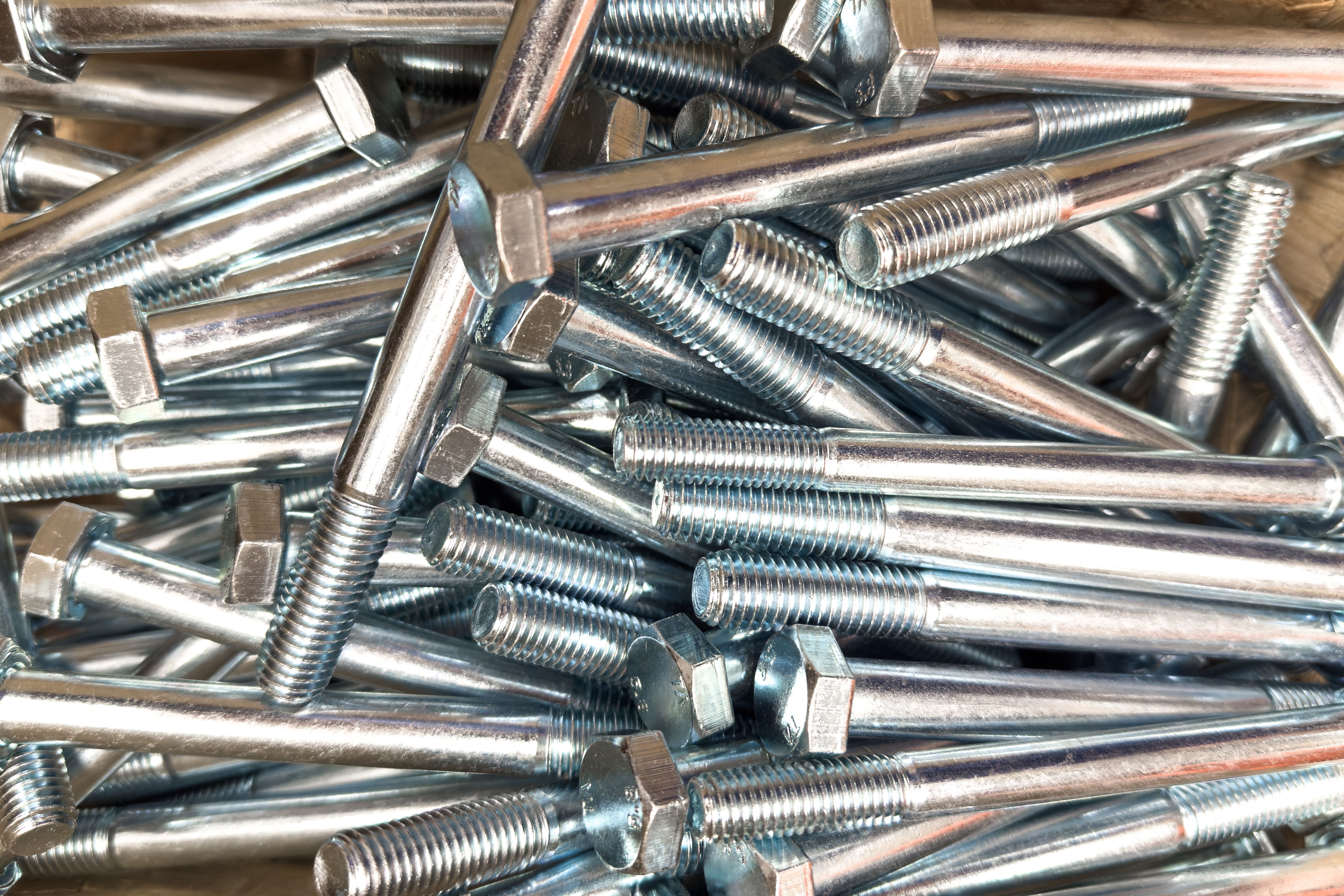 Various stainless steel bolts and nuts organized in a workshop setting for assembly