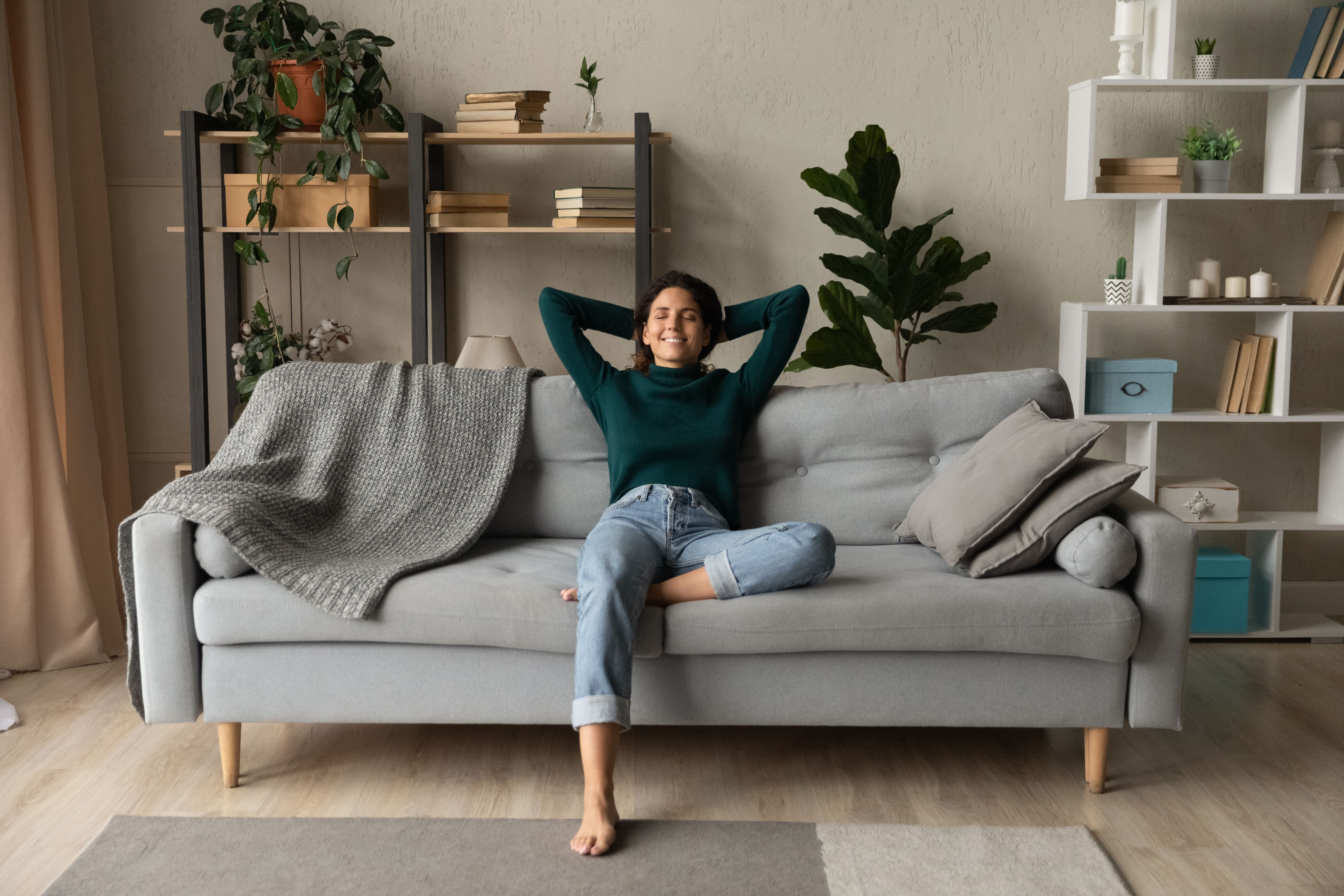 Young lady sit on sofa at home in relaxed pose