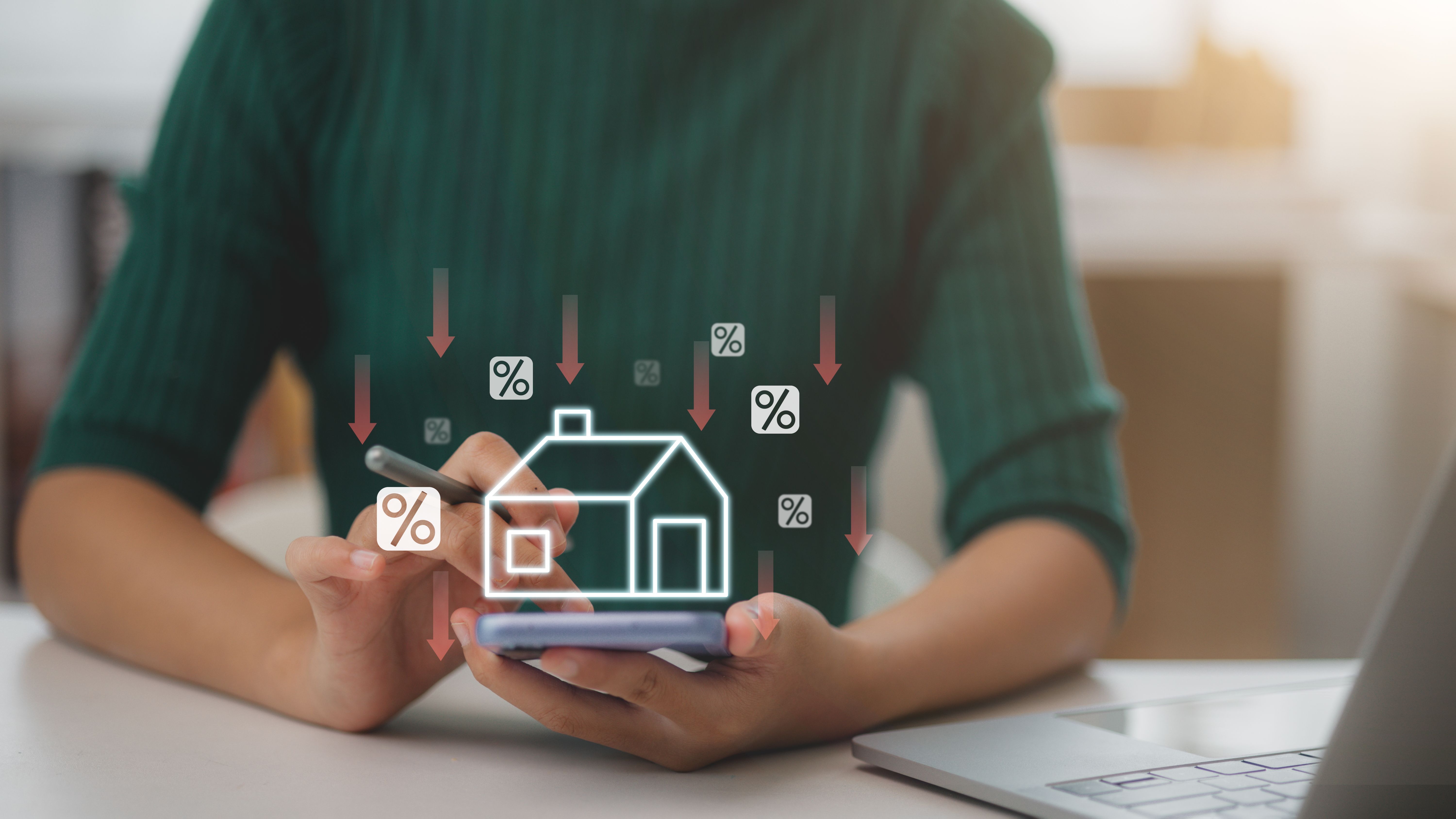 Women use smartphones with virtual home icons and down arrow for economical real estate and lower mortgage interest rates. Reduced prices for rental