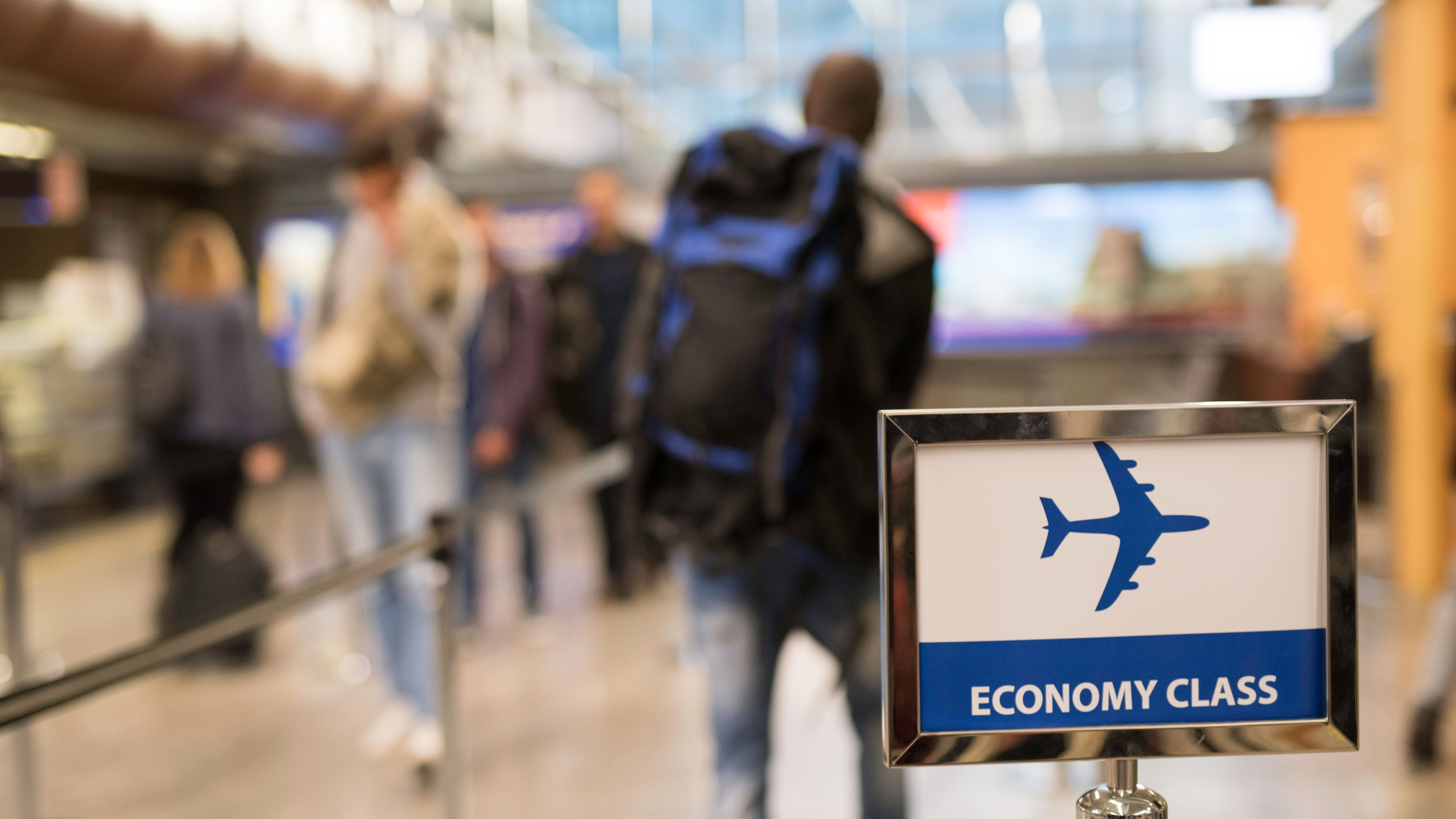 People boarding to airplane's economy class at an airport People boarding to airplane's economy class at an airport
