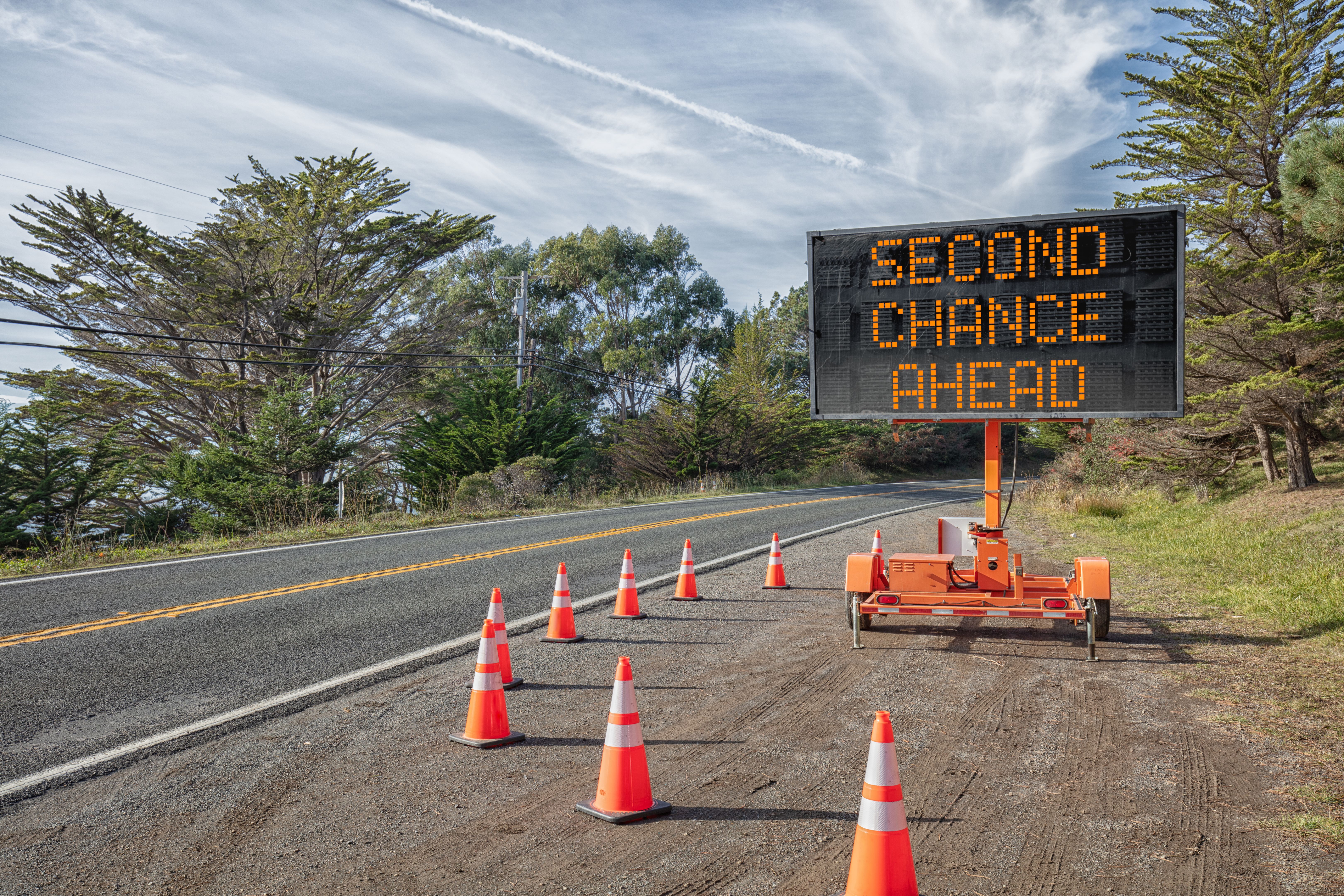 SECOND CHANCE AHEAD: Roadside sign: Trailer mobile warning sign parked by road with words for safety by orange cones