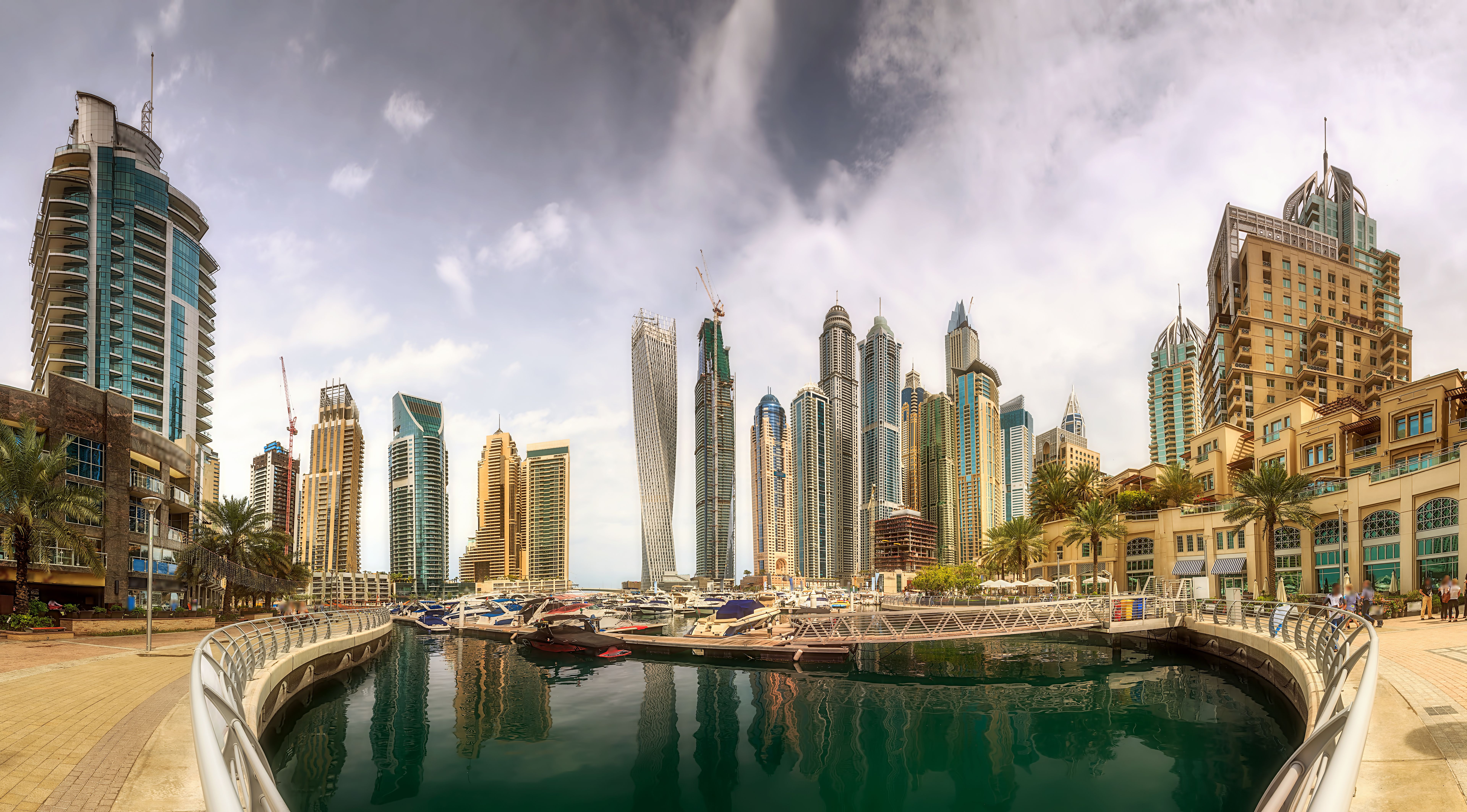 Panoramic view of Dubai Marina bay with yacht and cloudy sky, Dubai, UAE.