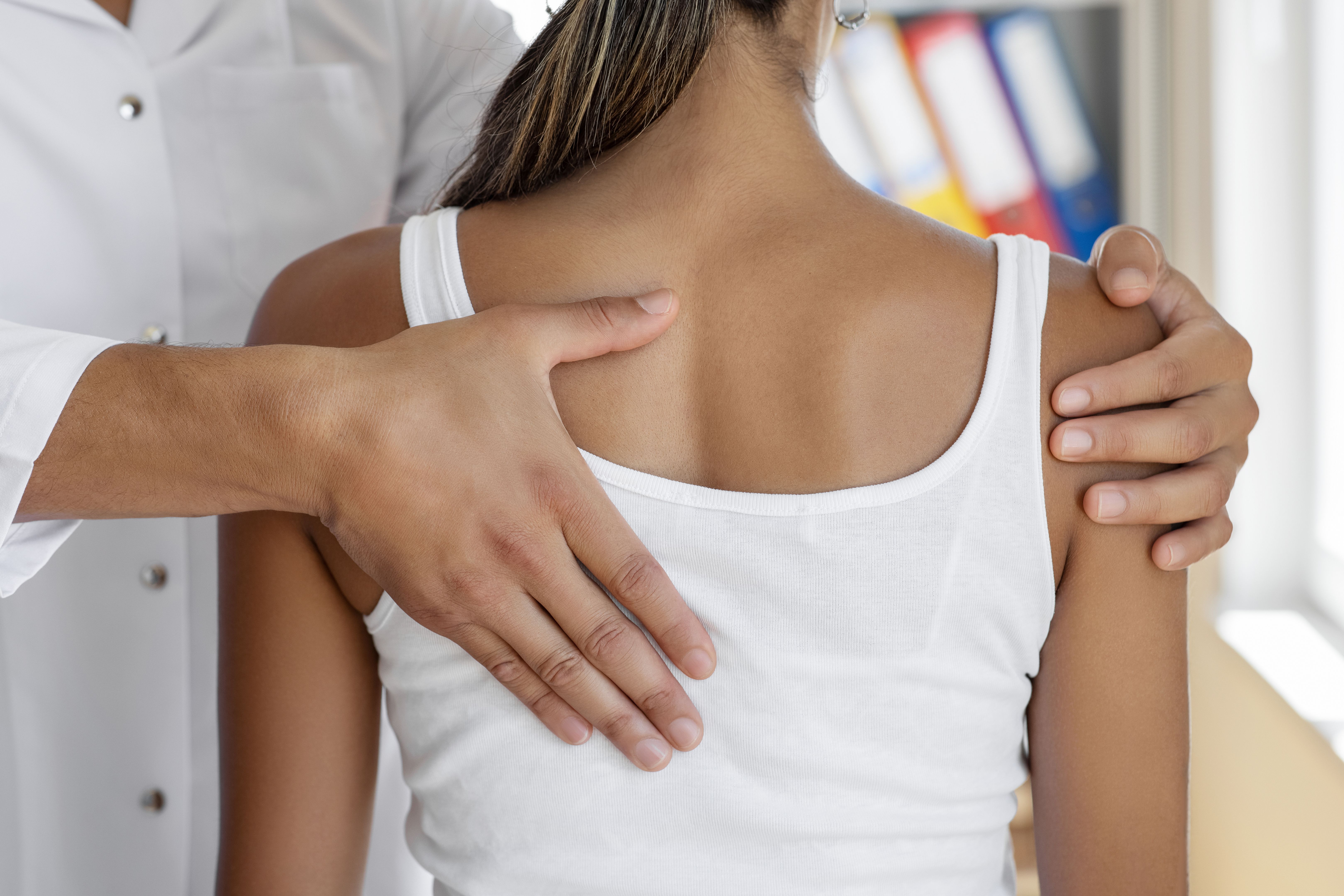 Médico fisioterapeuta fazendo tratamento de cura nas costas da mulher