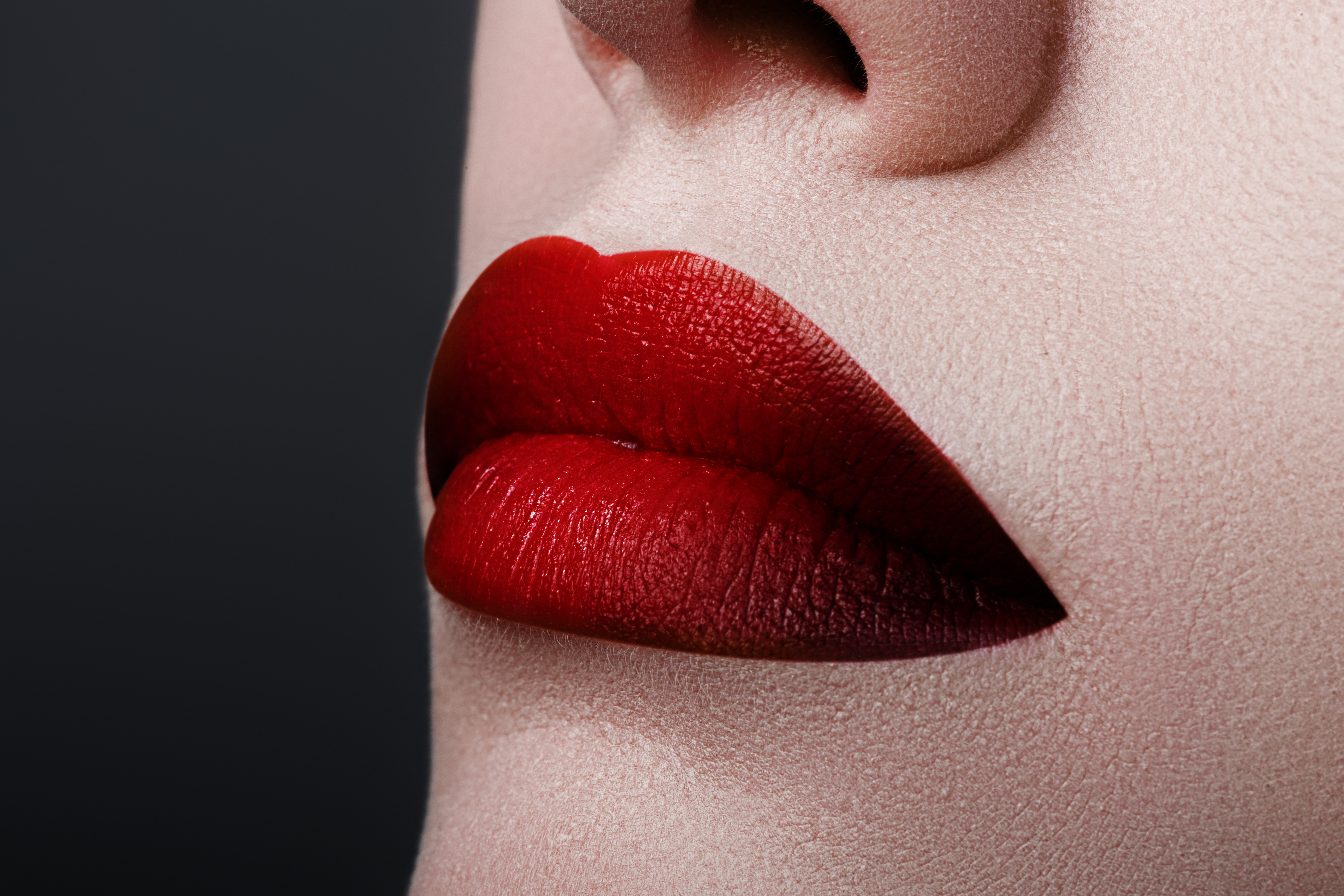 Extreme close up on model with dark red lipstick. Makeup. Profes