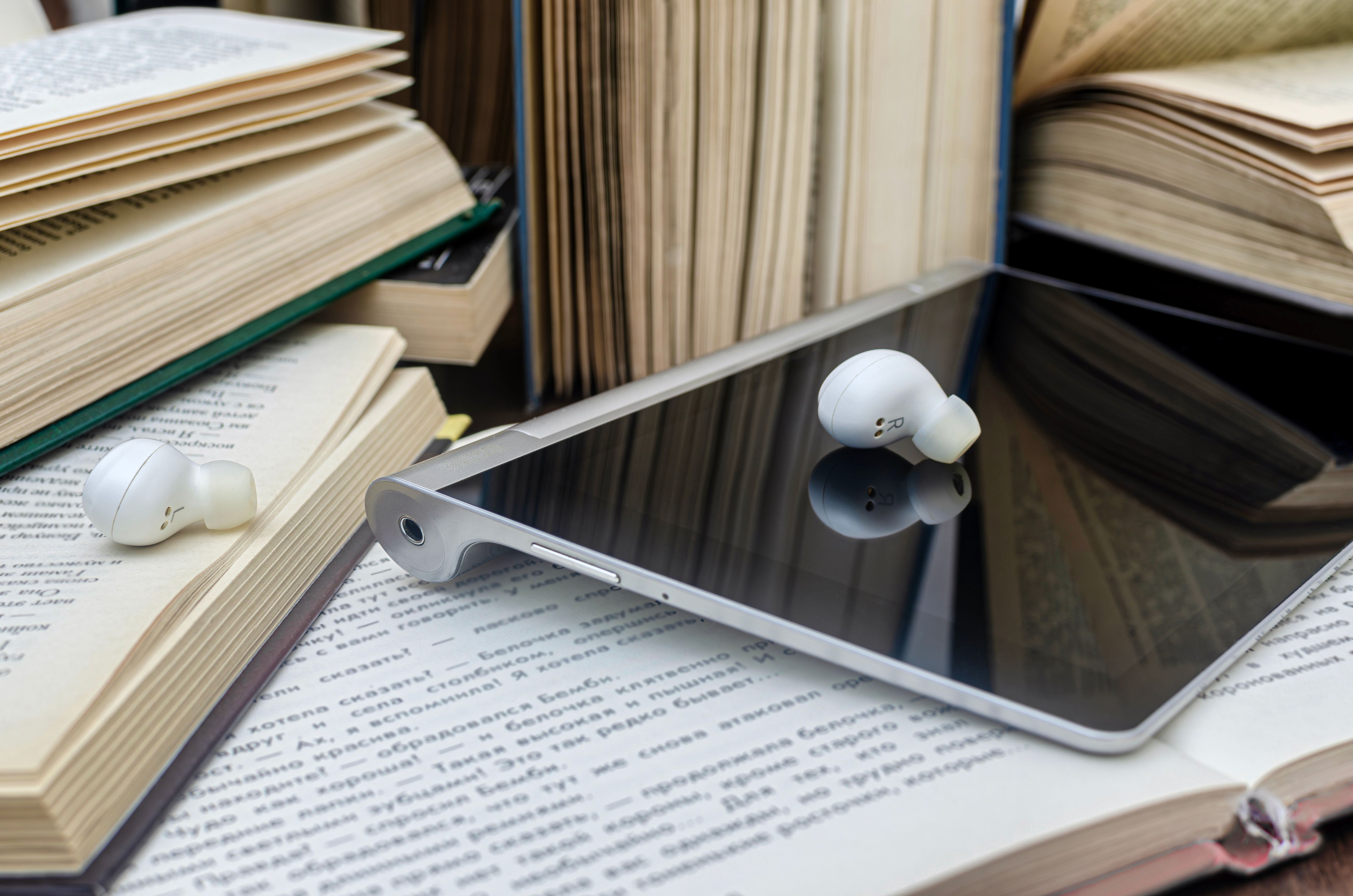 Stack of books and tablet with headphones